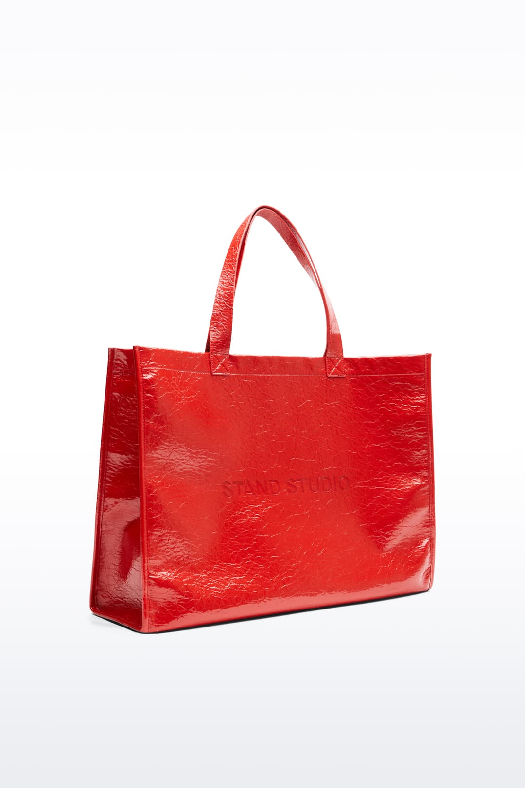Side view of the Tiana Shopper in Watermelon, is a classic tote bag crafted in bonded faux leather with a textured finish. The color is a bold red tone.