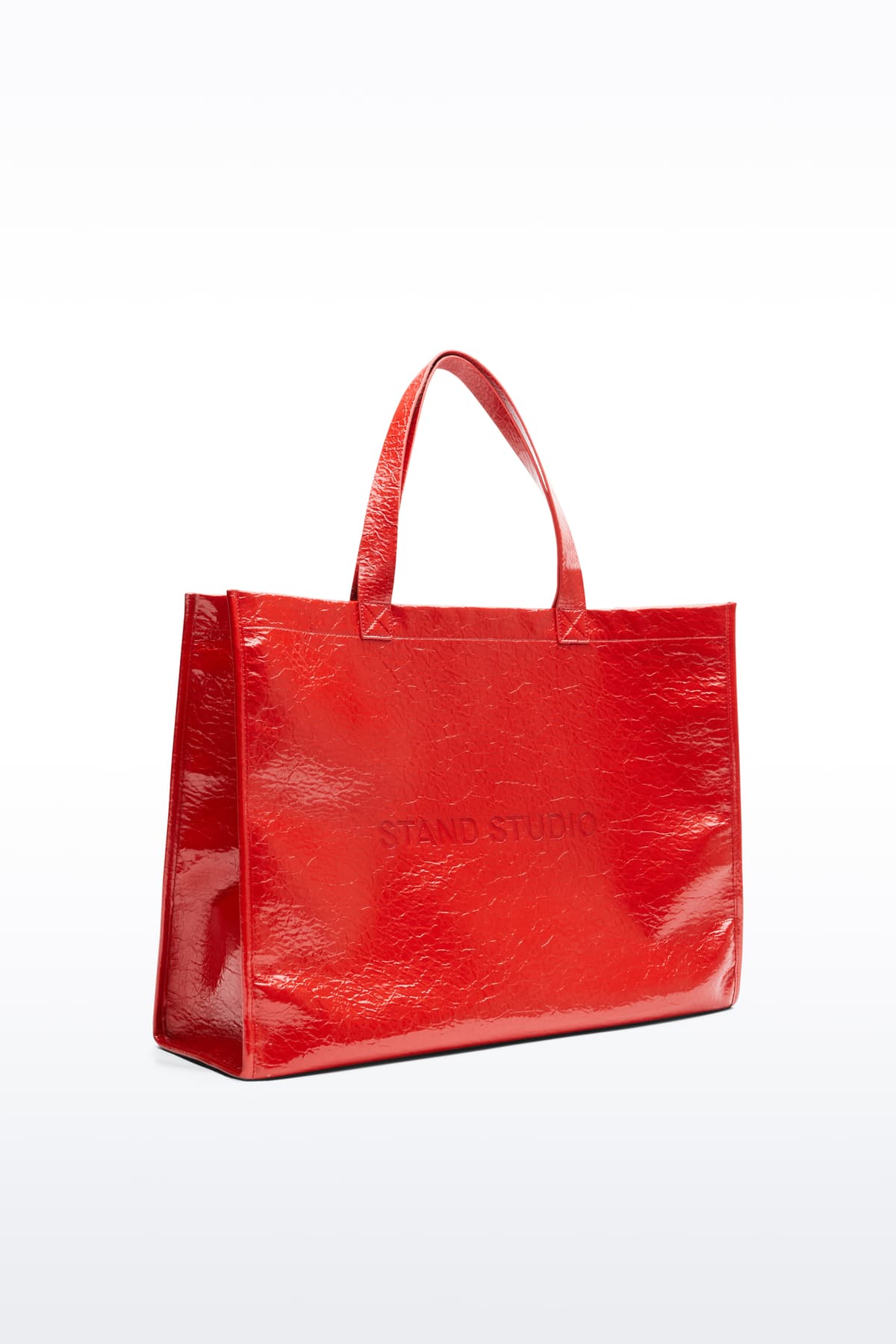 Side view of the Tiana Shopper in Watermelon, is a classic tote bag crafted in bonded faux leather with a textured finish. The color is a bold red tone.