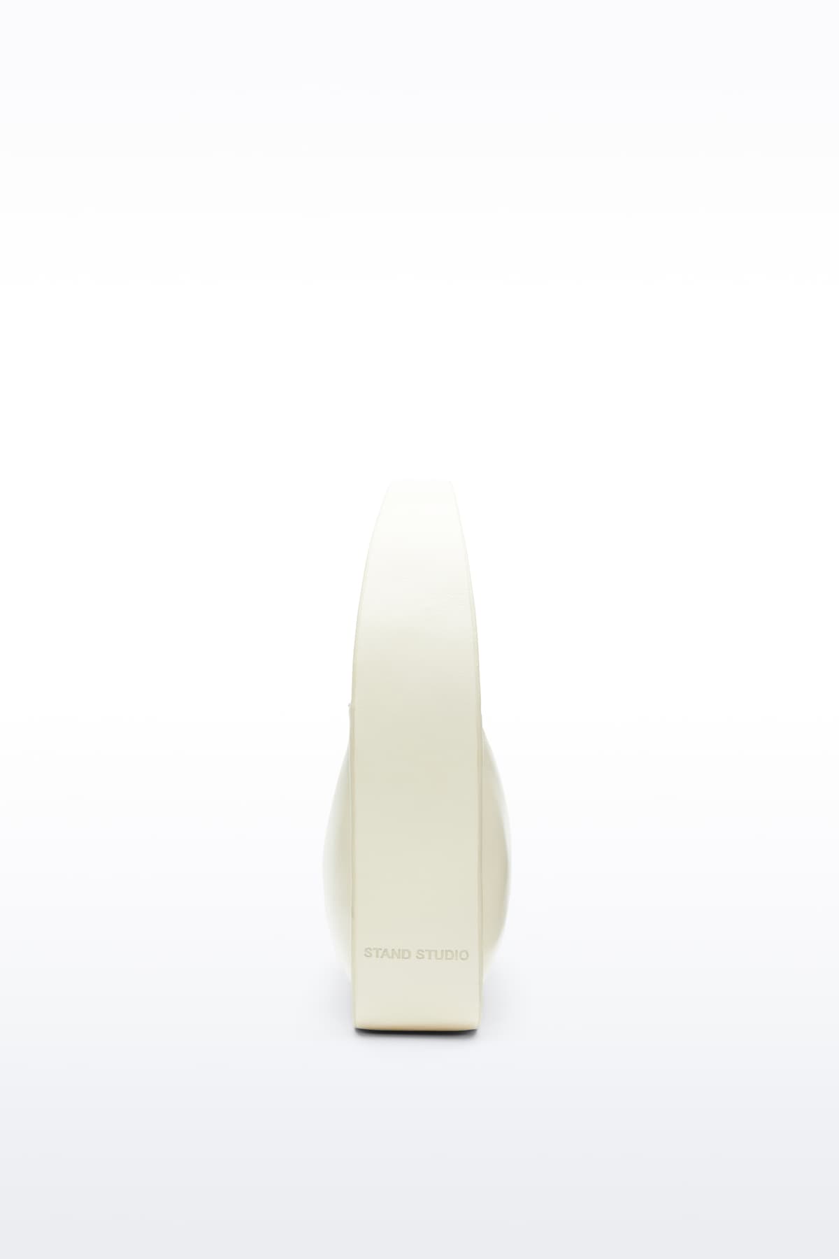 Side view of the Dakota Bag in Pina Colada, Dakota is a handbag crafted from genuine lamb leather and designed for a sleek, baguette-shaped silhouette. The color is a pale yellow tone.