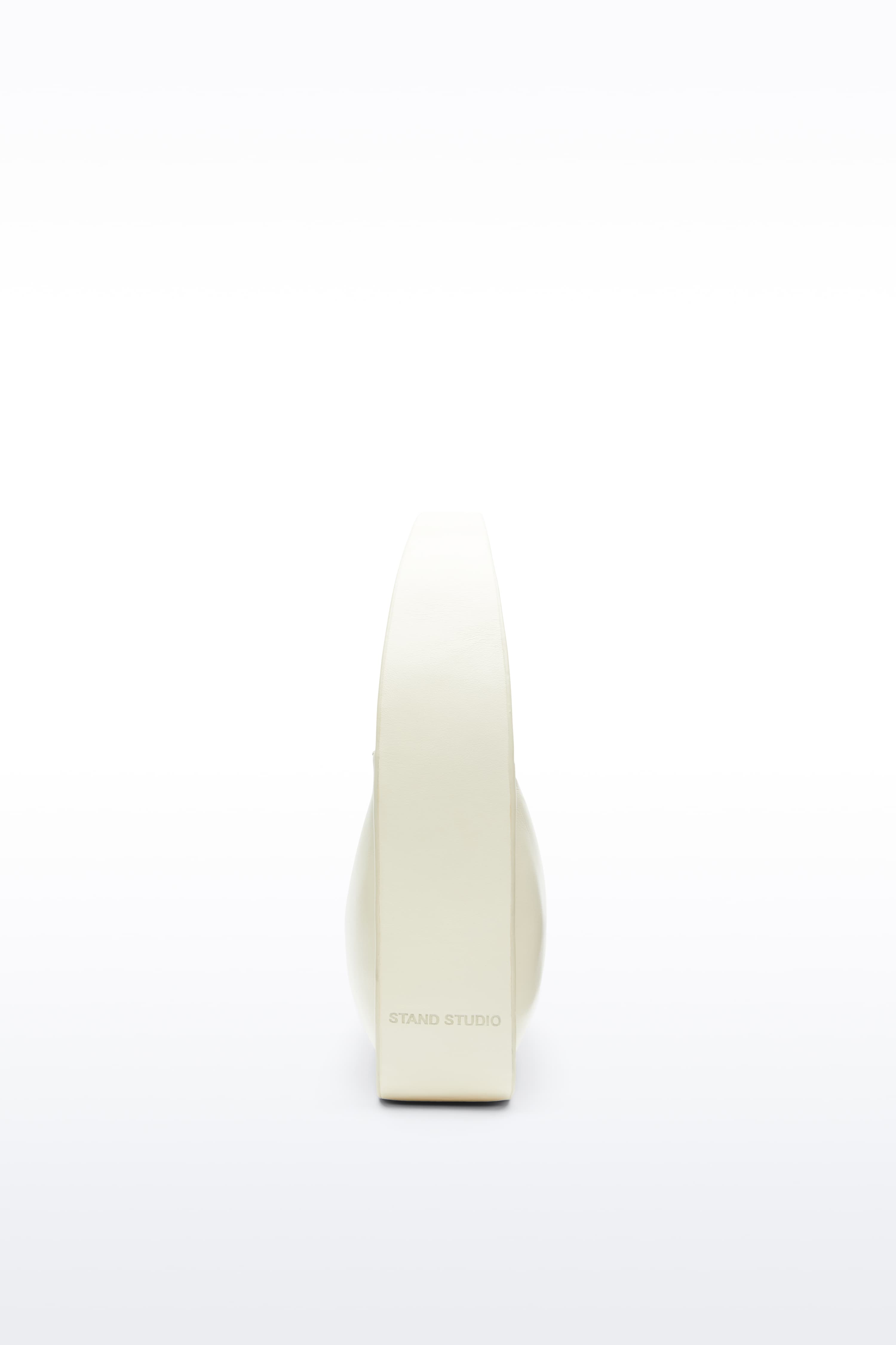 Side view of the Dakota Bag in Pina Colada, Dakota is a handbag crafted from genuine lamb leather and designed for a sleek, baguette-shaped silhouette. The color is a pale yellow tone.