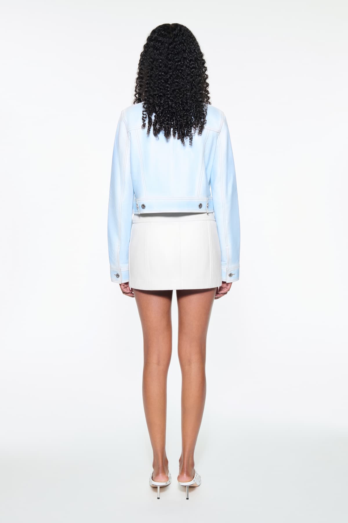 Back view of the Calliope Jacket in Blue Lagoon, is crafted in supple lamb leather and features a cropped silhouette. The color is a soft light blue.