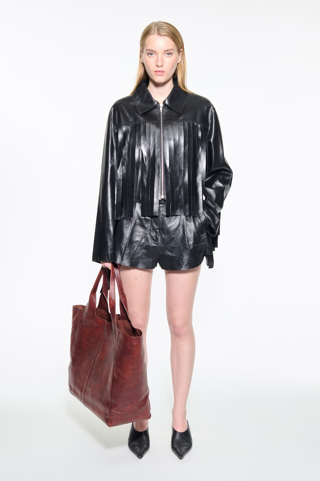 Front view of the Charlotta Fringe Jacket in Black, is designed in leather with a cropped silhouette and raw edge finishes.