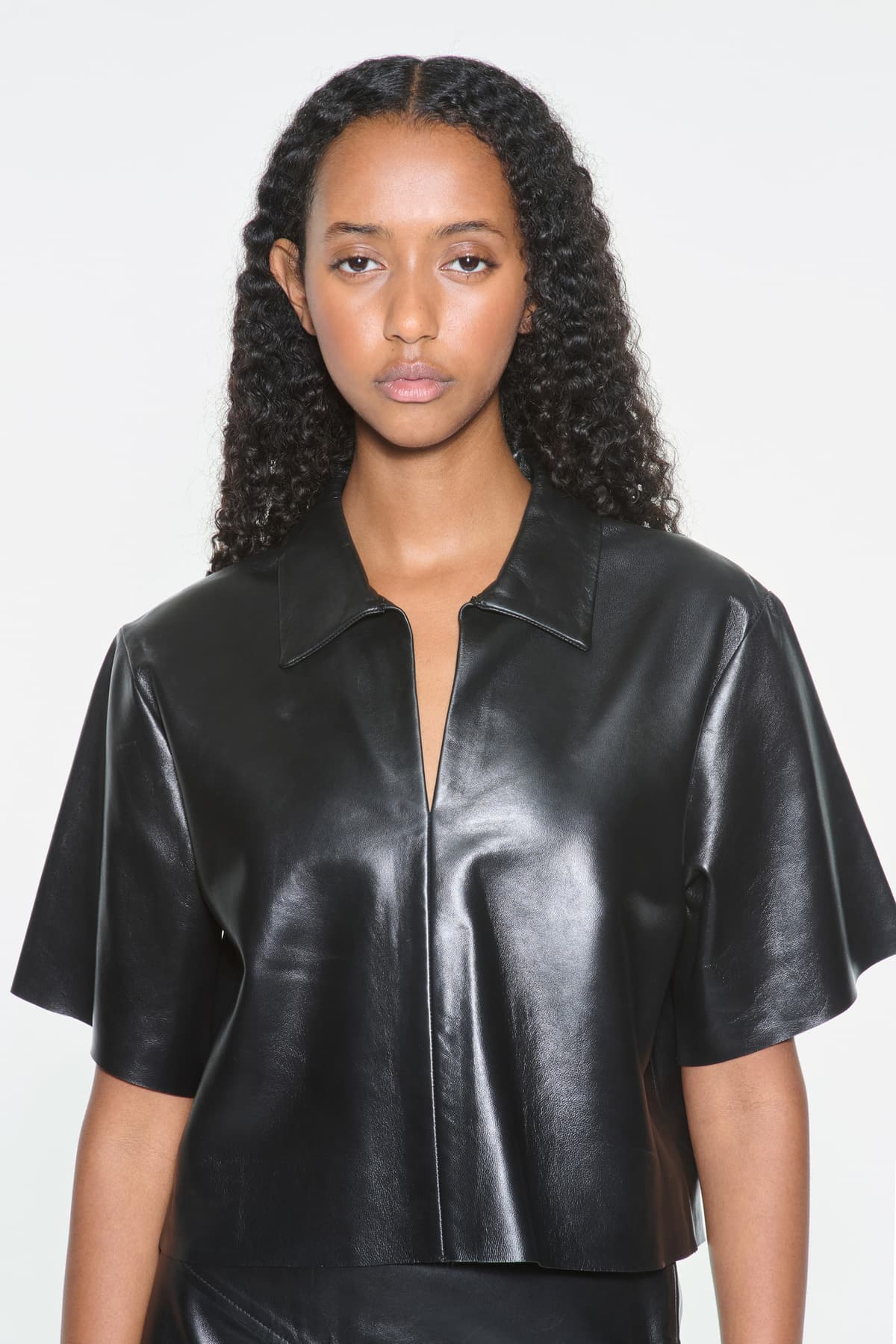 Close-up view of the Julissa Shirt in Black, is designed in leather with a relaxed silhouette.
