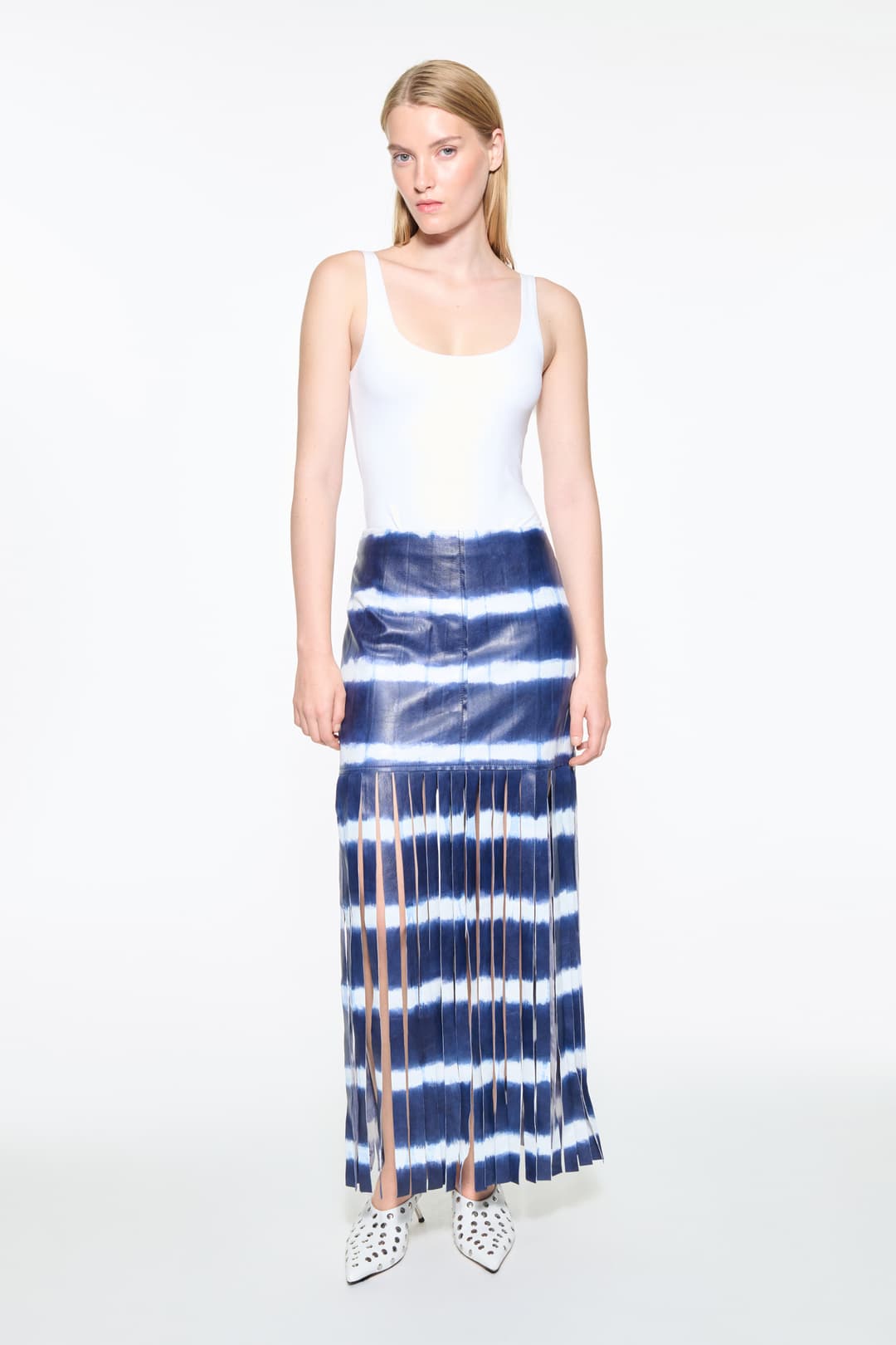 Front view of the Viviana Fringe Skirt in Ocean Tie Dye, is made from leather and features a clean, contemporary silhouette with raw edge fringes. The color is a dark blue with white tie-dye pattern.