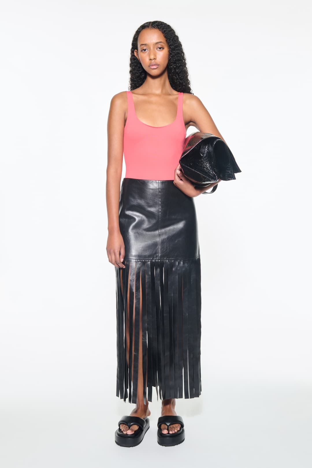 Front view of the Viviana Fringe Skirt in Black, is made from leather and features a clean, contemporary silhouette with raw edge fringes.