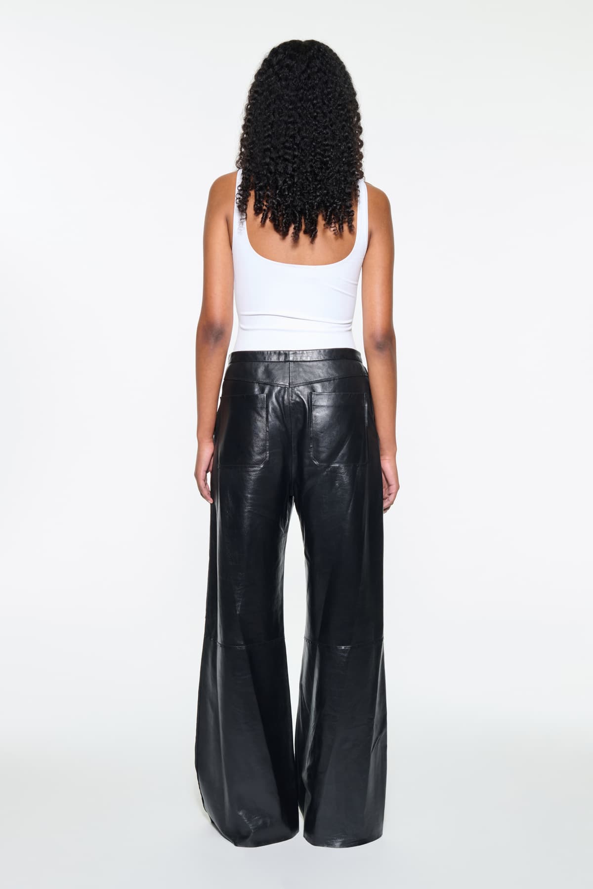 Back view of the Rowyn Trousers in Black, are crafted in leather and are designed for a wide silhouette.