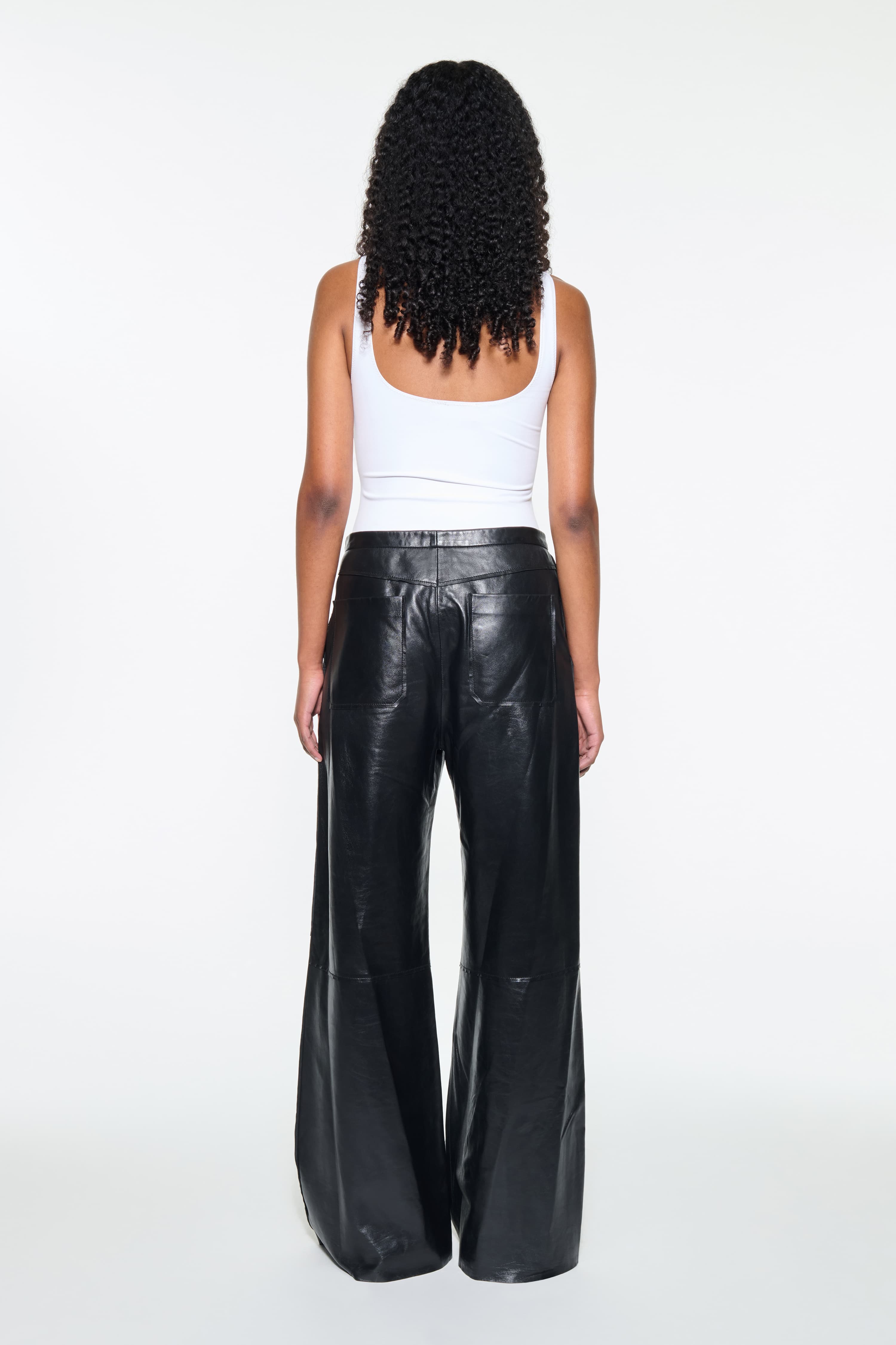 Back view of the Rowyn Trousers in Black, are crafted in leather and are designed for a wide silhouette.