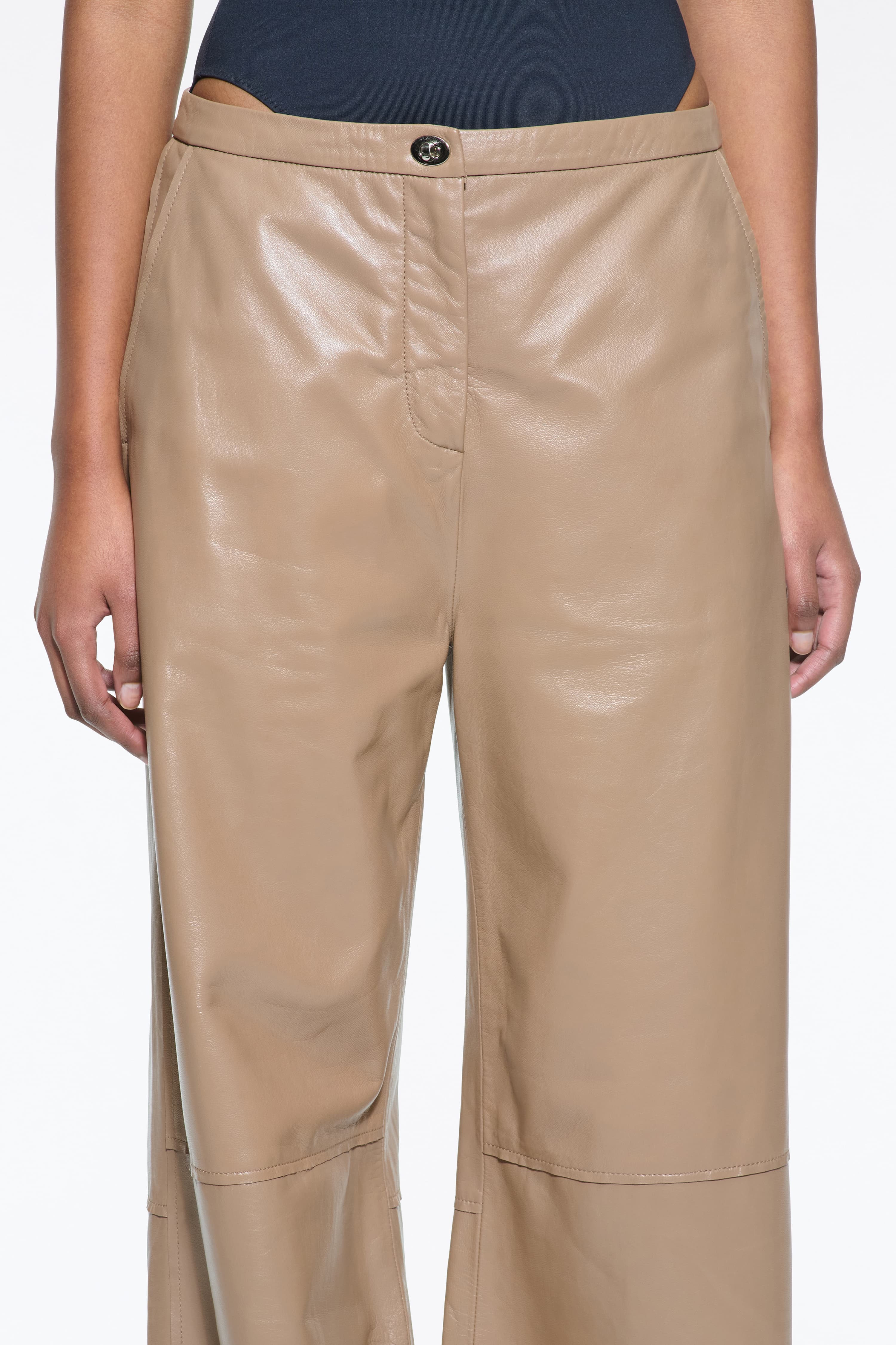 Close-up view of the Rowyn Trousers in Coconut Brown, are crafted in leather and are designed for a wide silhouette. The color is a light brown shade.