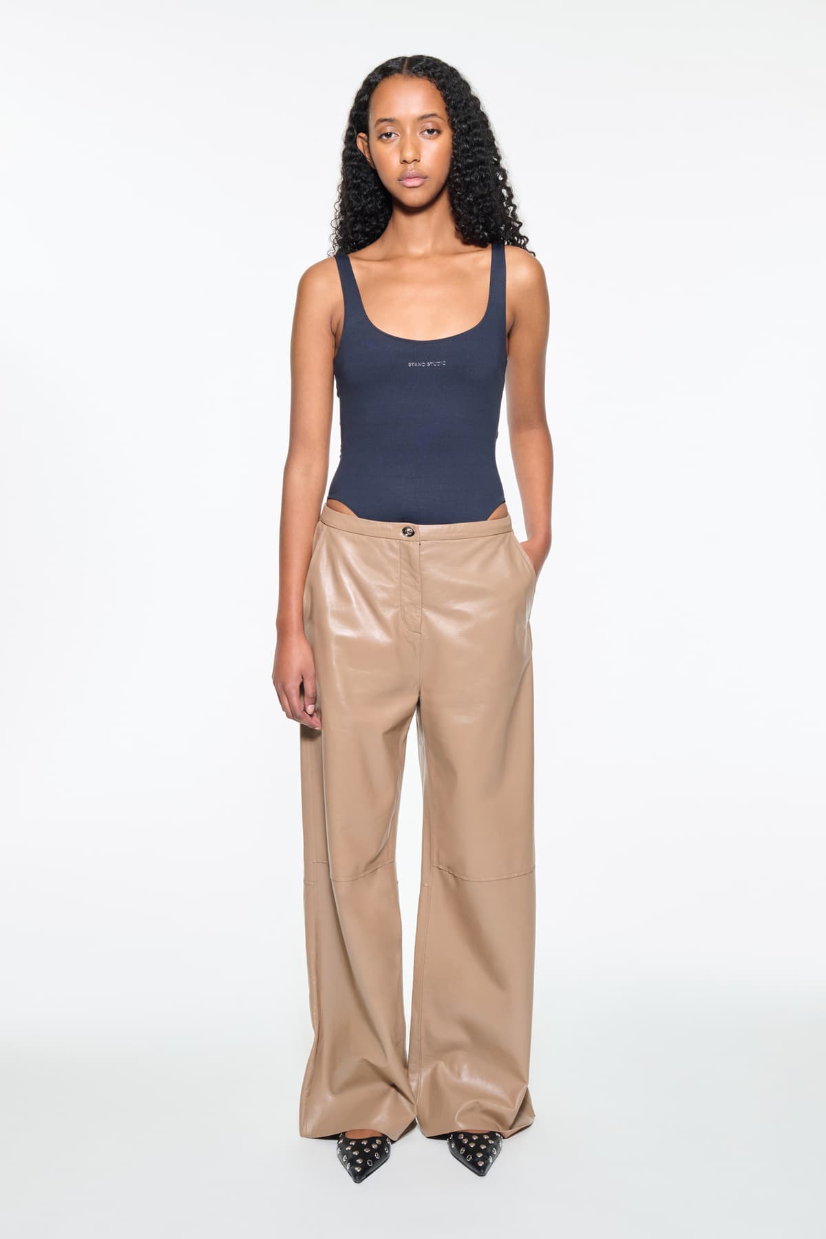 Front view of the Rowyn Trousers in Coconut Brown, are crafted in leather and are designed for a wide silhouette. The color is a light brown shade.