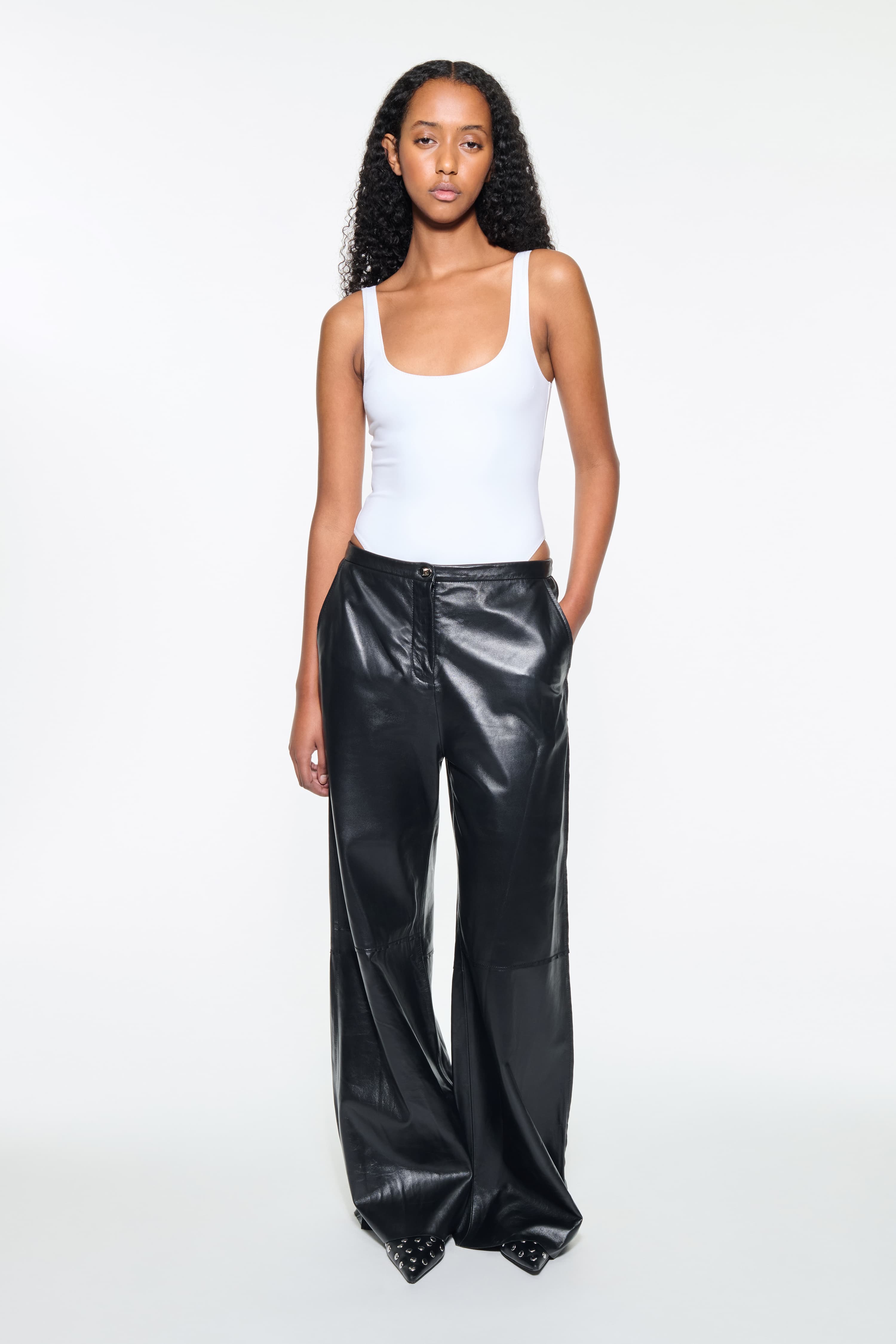 Front view of the Rowyn Trousers in Black, are crafted in leather and are designed for a wide silhouette.