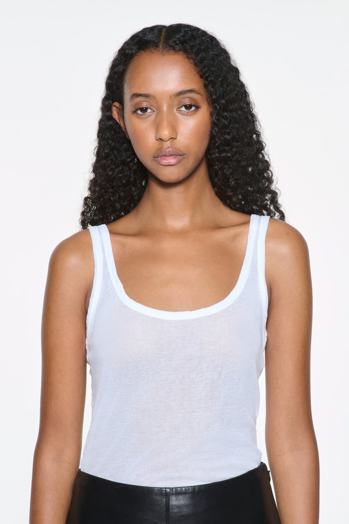 Close-up view of the Amoura Top in White, is a tank top crafted from soft ribbed fabric.