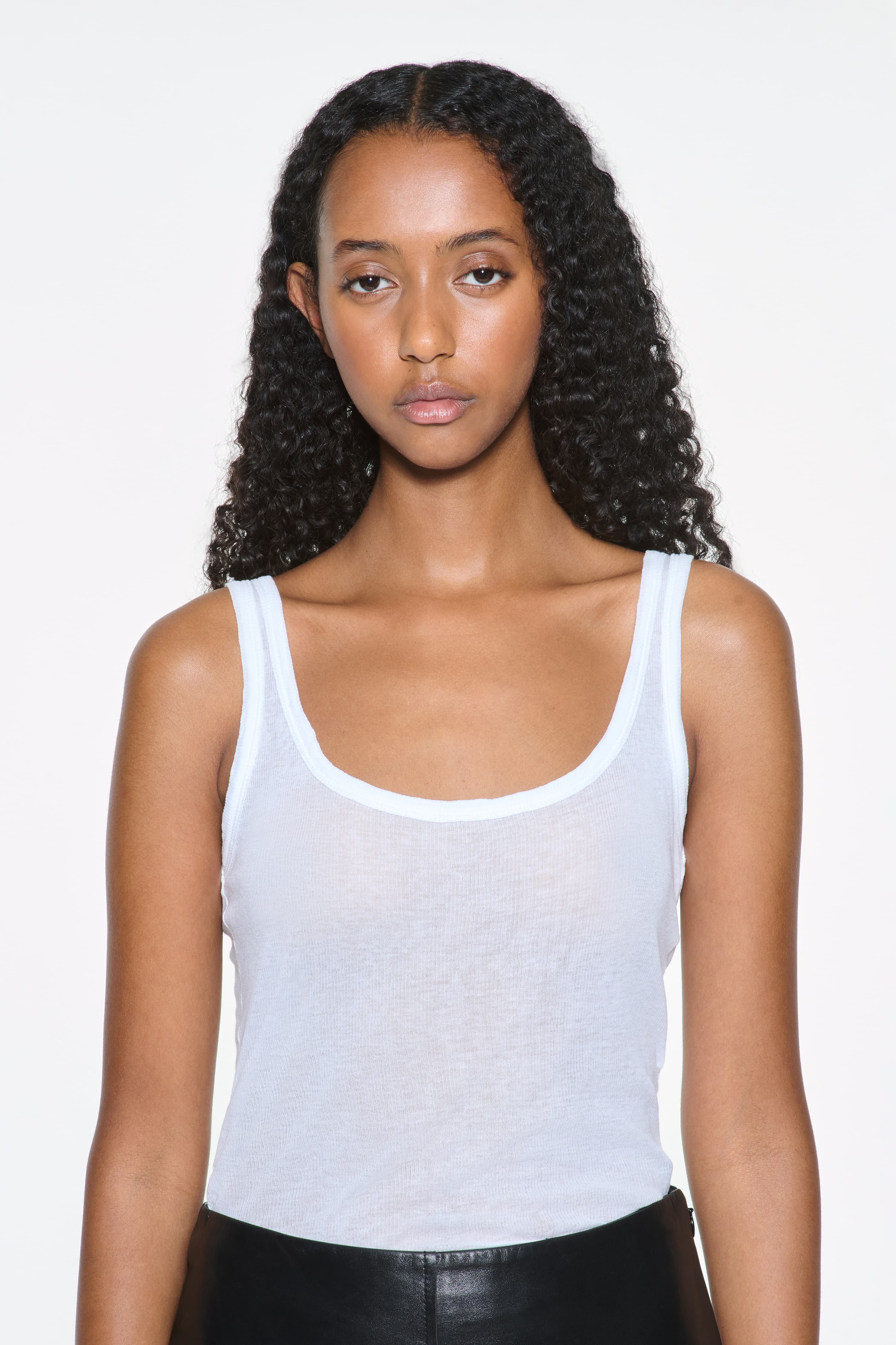 Close-up view of the Amoura Top in White, is a tank top crafted from soft ribbed fabric.