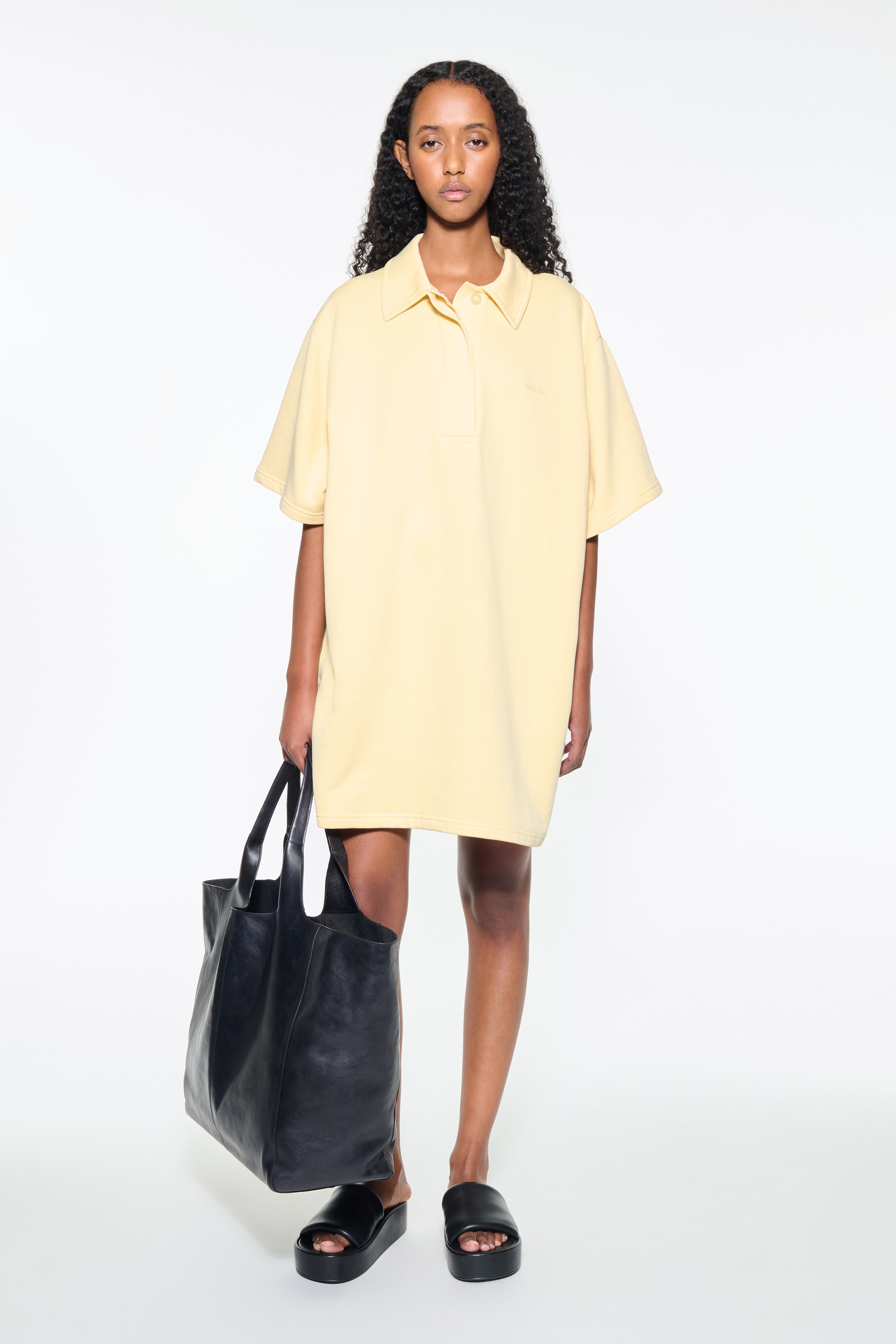 Front view of the Kennedi Polo Dress in Pina Colada/Logo, is a casual, knee-length dress with a polo collar made from lightweight jersey fabric.