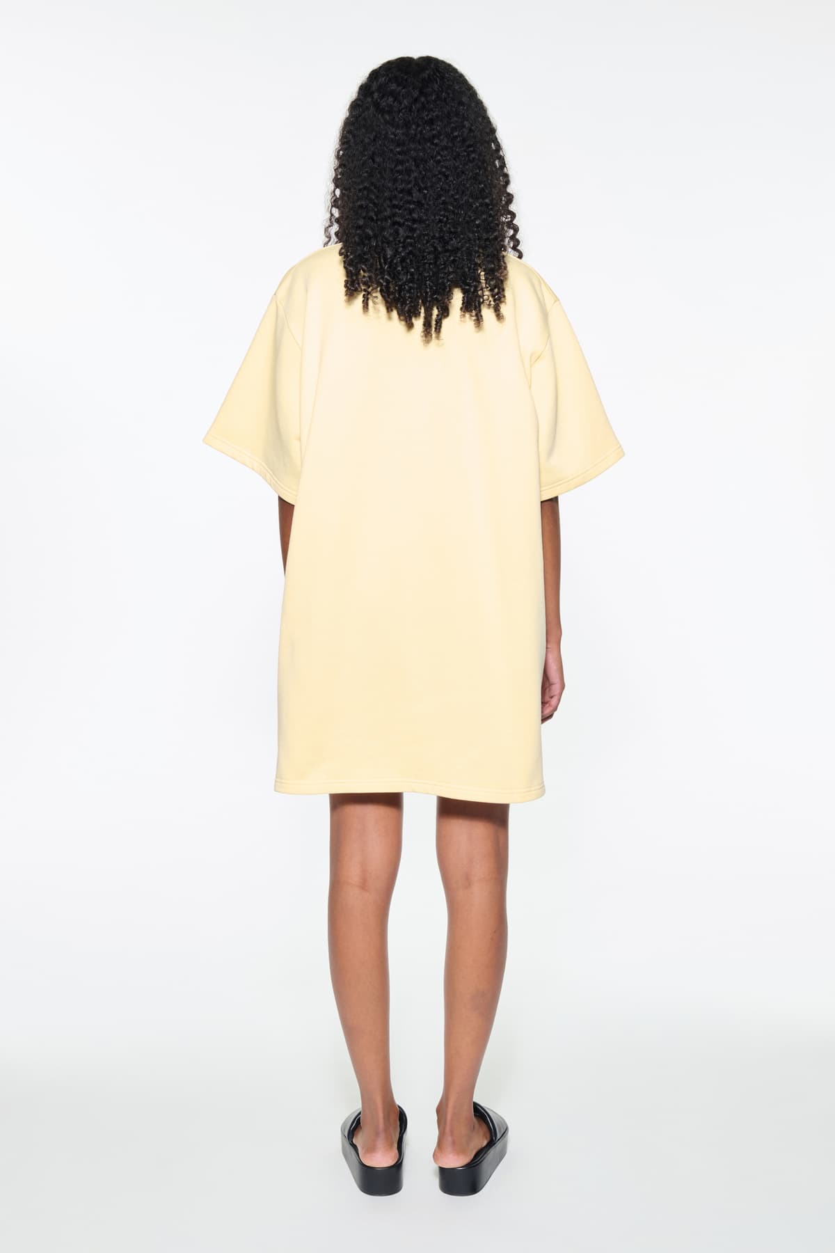 Back view of the Kennedi Polo Dress in Pina Colada/Logo, is a casual, knee-length dress with a polo collar made from lightweight jersey fabric.