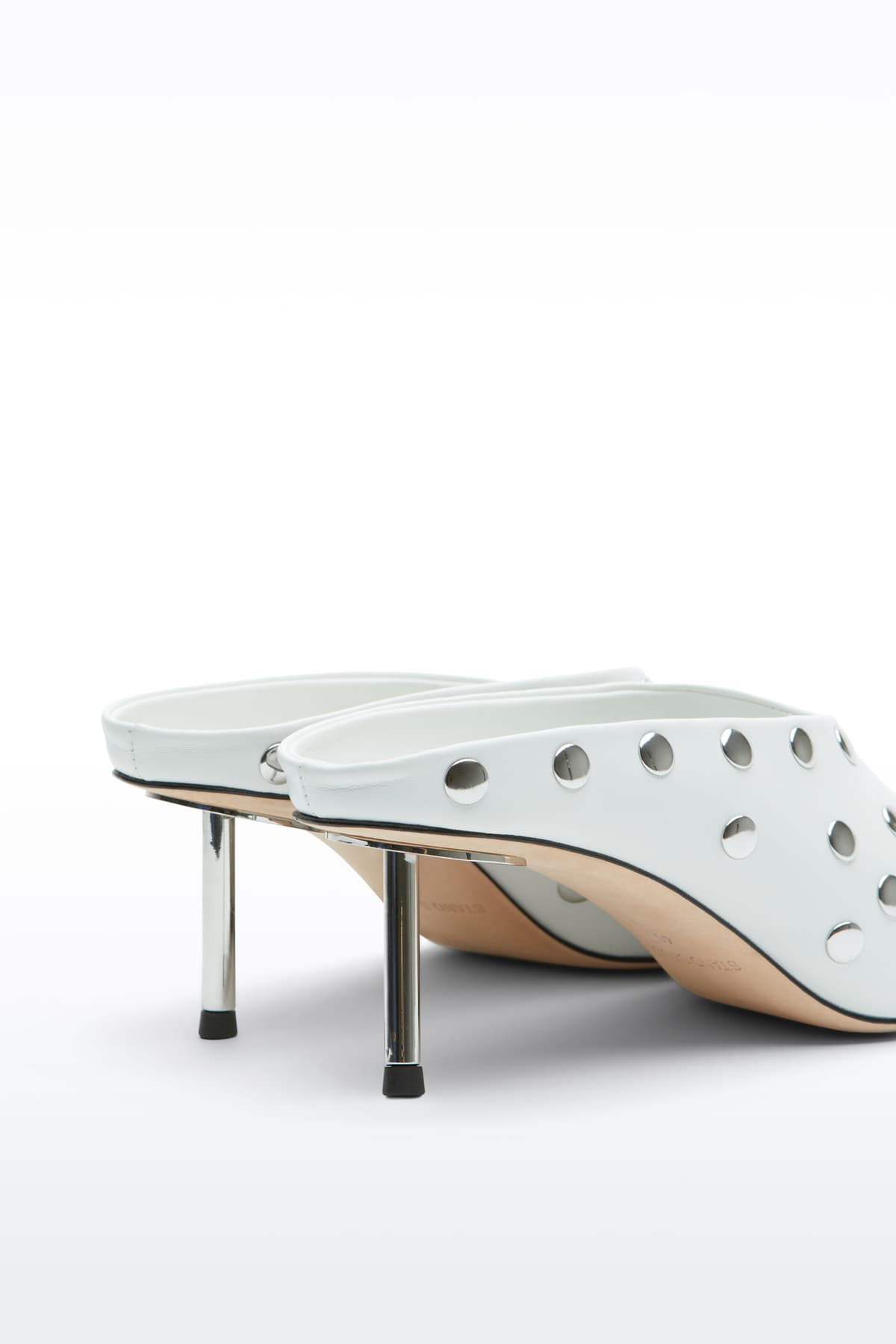 Close-up view of the Kelsey Studded Mule in White, Kelsey Mule is a slip-on mule crafted in smooth nappa leather with sleek metallic studs.