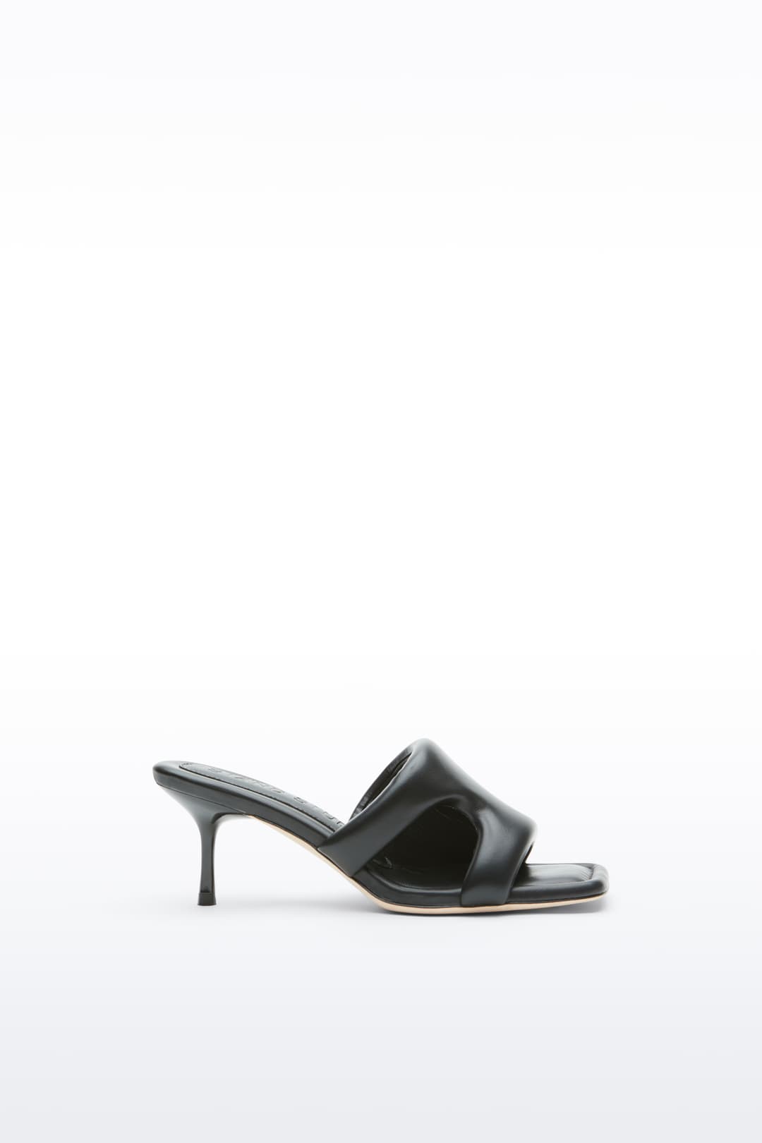 Side view of the Molly Mule in Black, is a minimalist mule featuring a padded faux leather upper and a sleek silhouette.