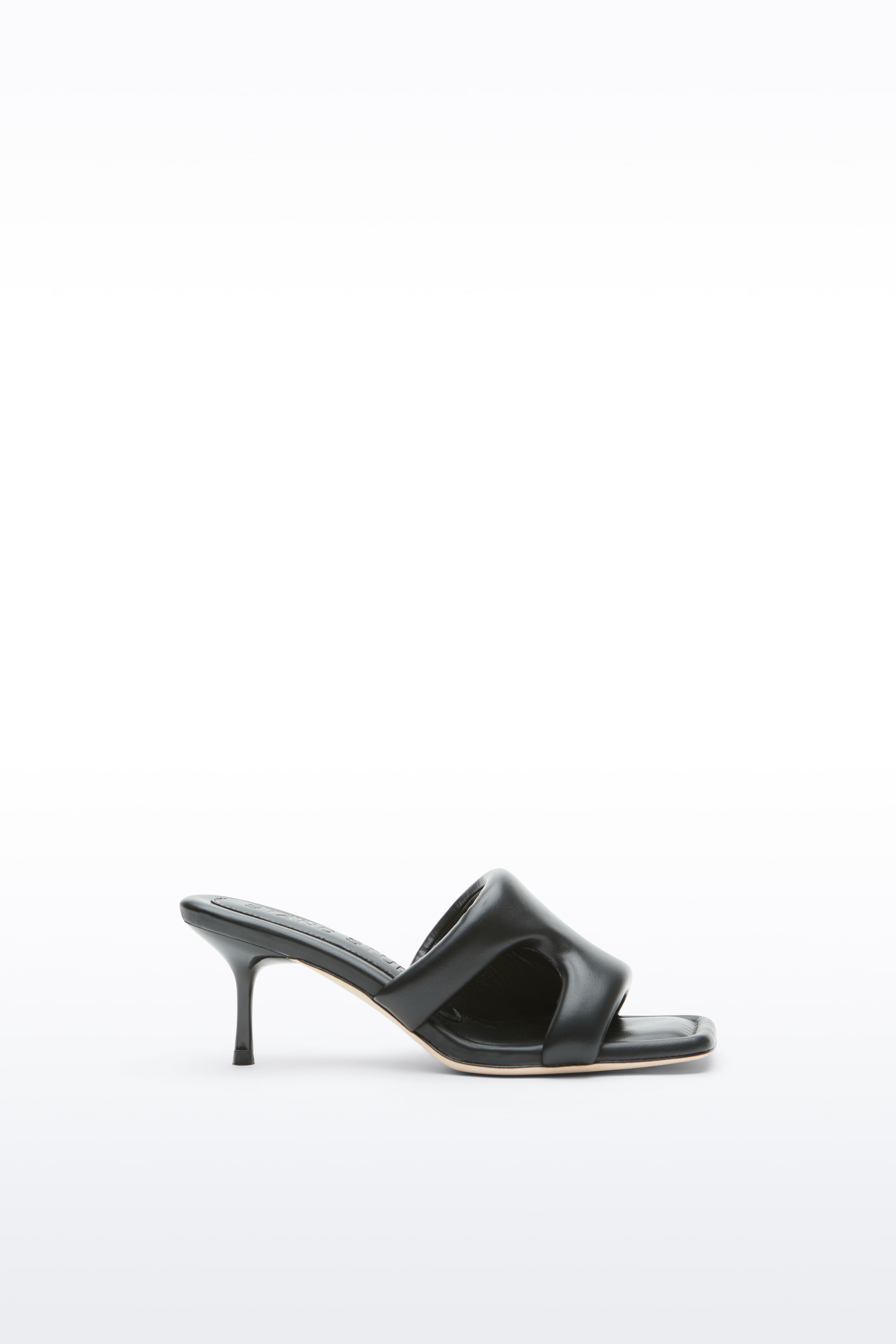 Side view of the Molly Mule in Black, is a minimalist mule featuring a padded faux leather upper and a sleek silhouette.