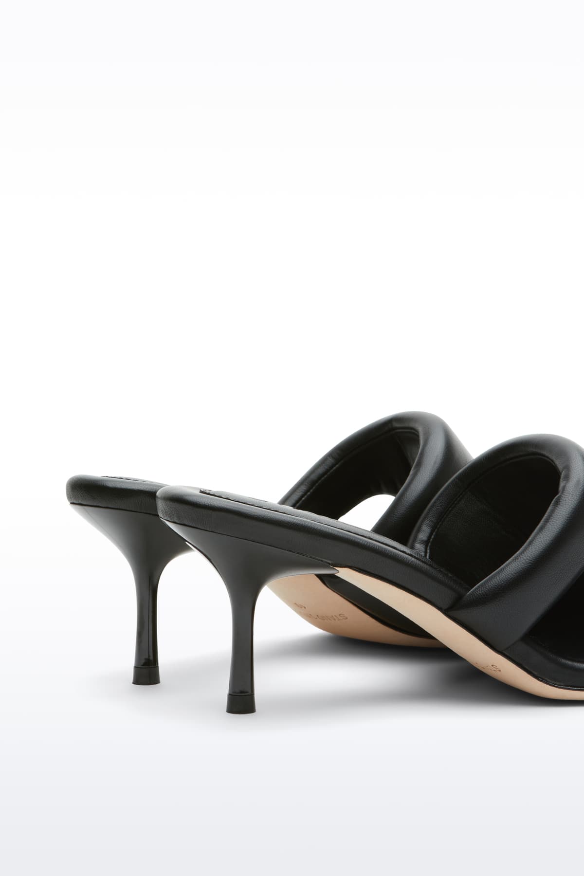 Close-up view of the Molly Mule in Black, is a minimalist mule featuring a padded faux leather upper and a sleek silhouette.