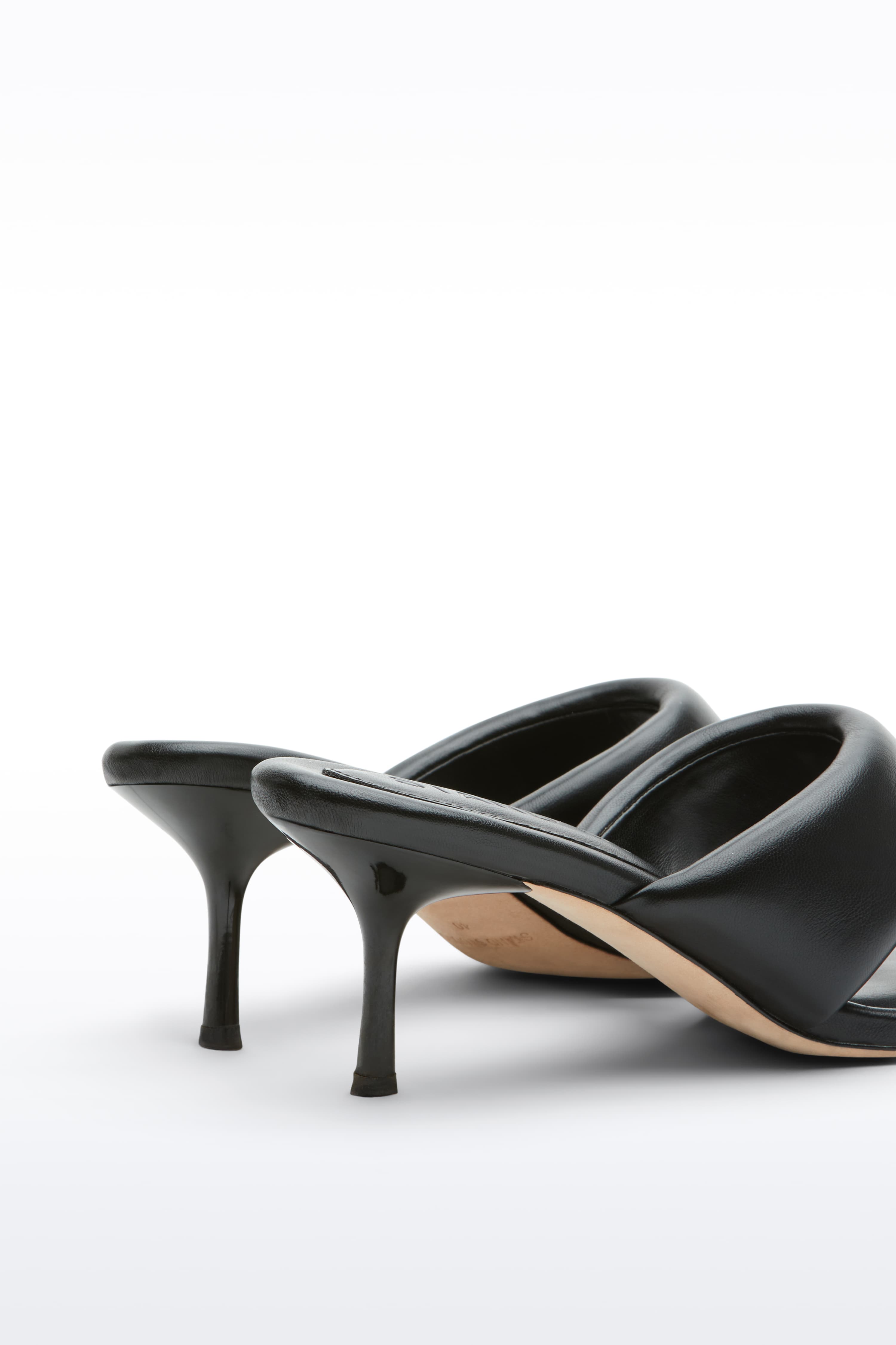 Close-up view of the Jessica Mule in Black, Jessica Padded Mule is a heeled mule featuring a padded faux leather upper with a sleek thong-strap design.