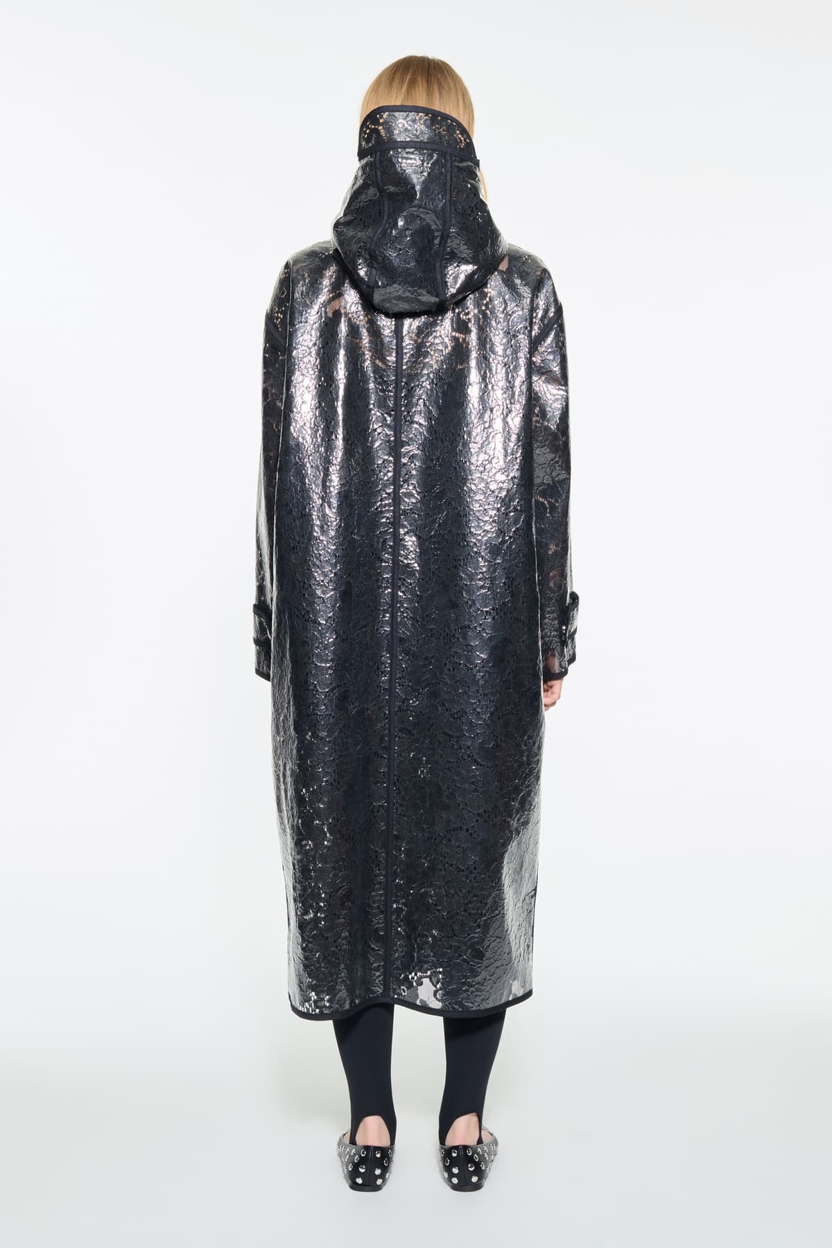 Back view of the True Raincoat in Black, is a lightweight raincoat with a lace-patterned design.
