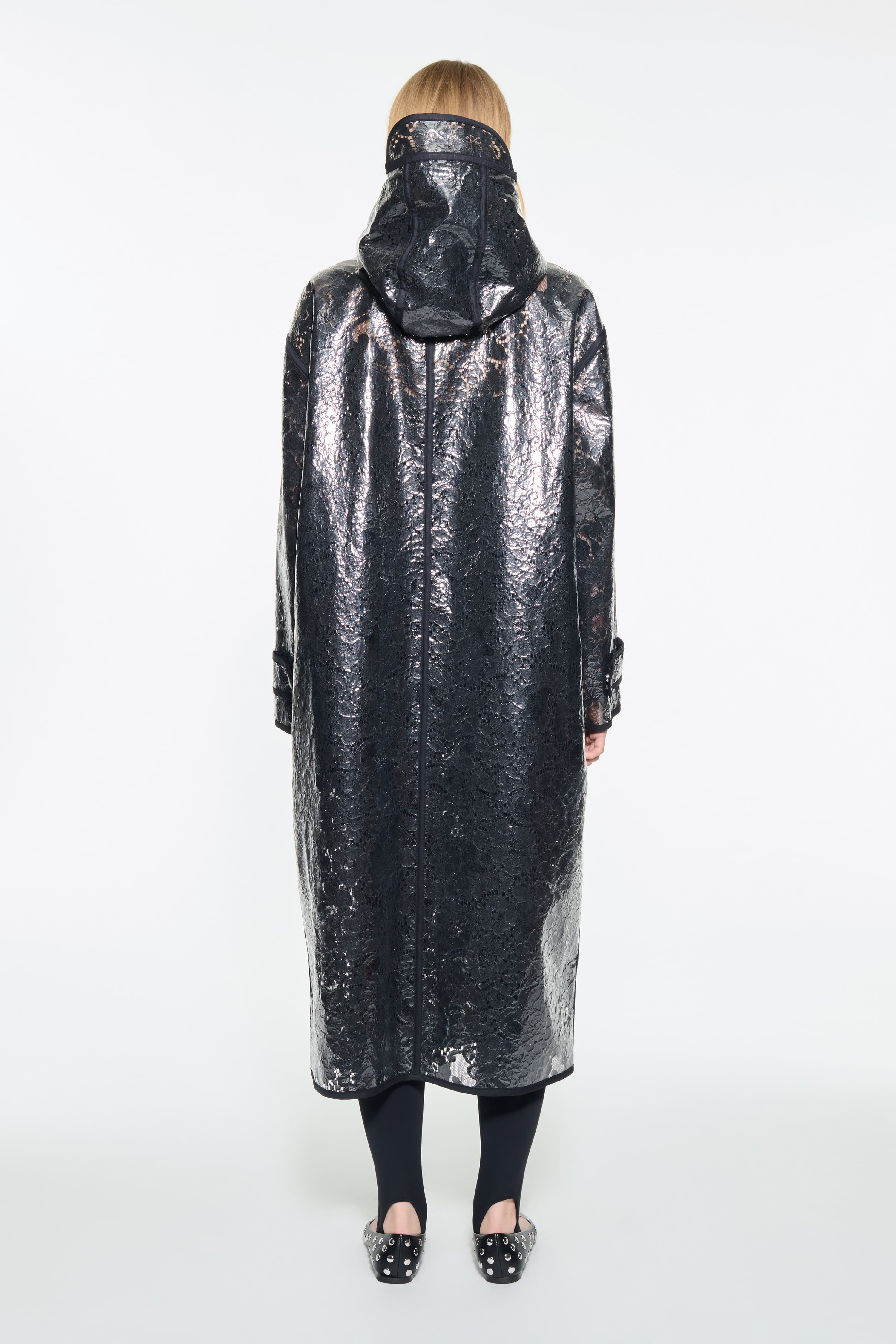 Back view of the True Raincoat in Black, is a lightweight raincoat with a lace-patterned design.
