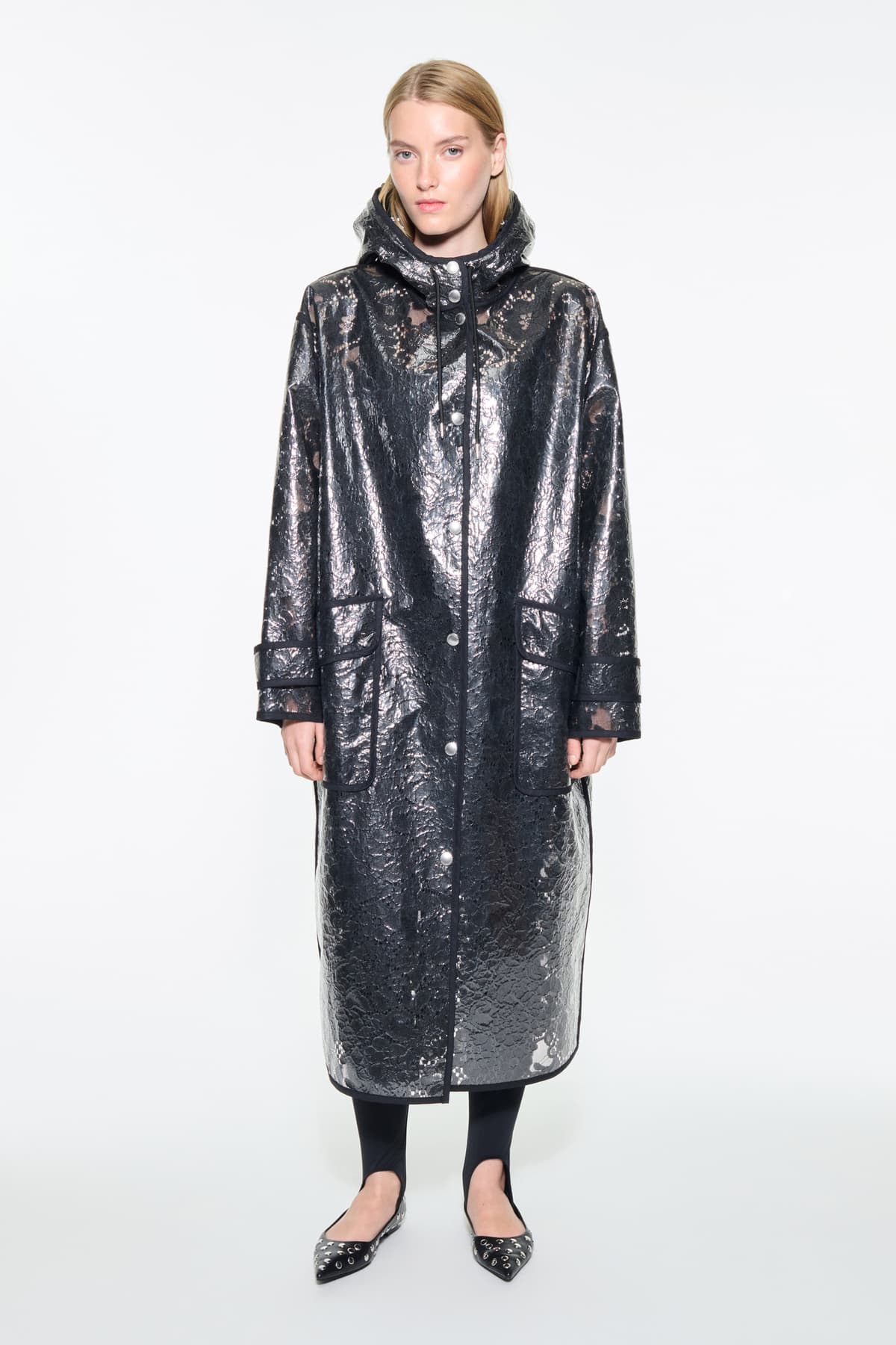 Front view of the True Raincoat in Black, is a lightweight raincoat with a lace-patterned design.