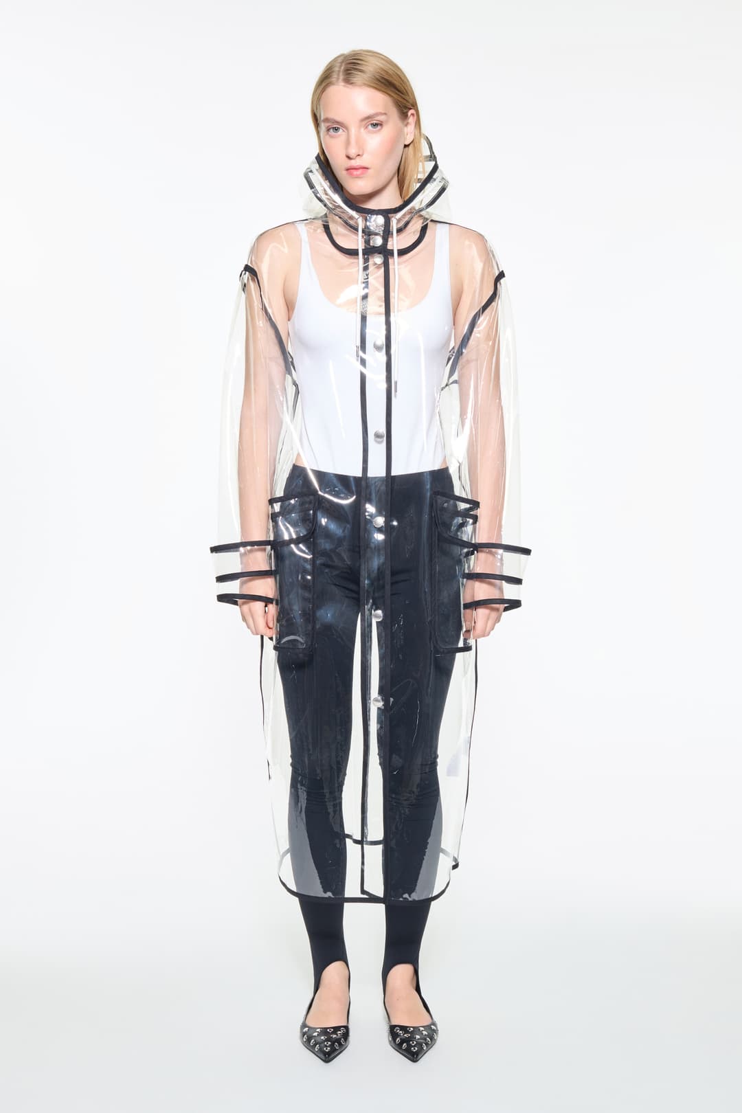 Front view of the True Raincoat in Transparent, is a lightweight, fully transparent raincoat with contrast binding details.