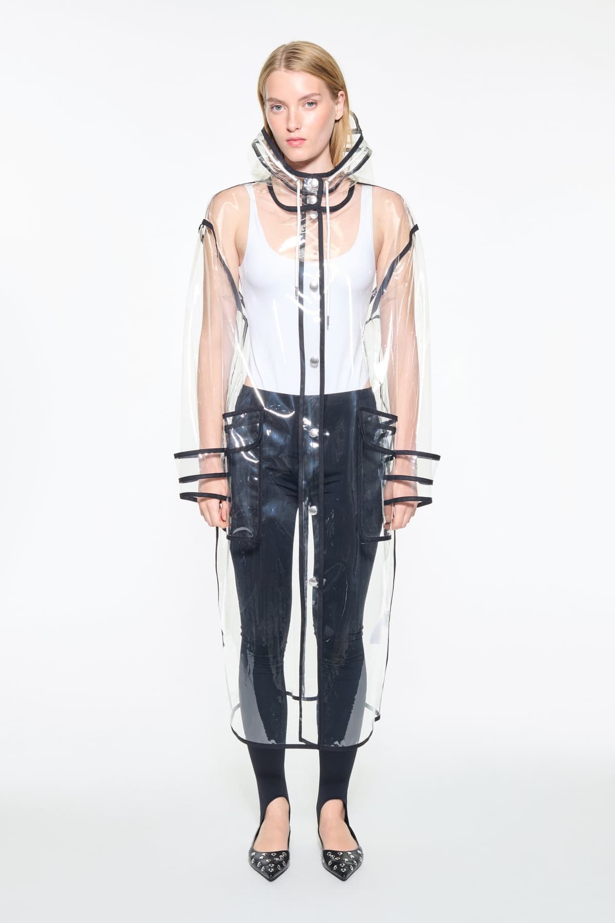 Front view of the True Raincoat in Transparent, is a lightweight, fully transparent raincoat with contrast binding details.