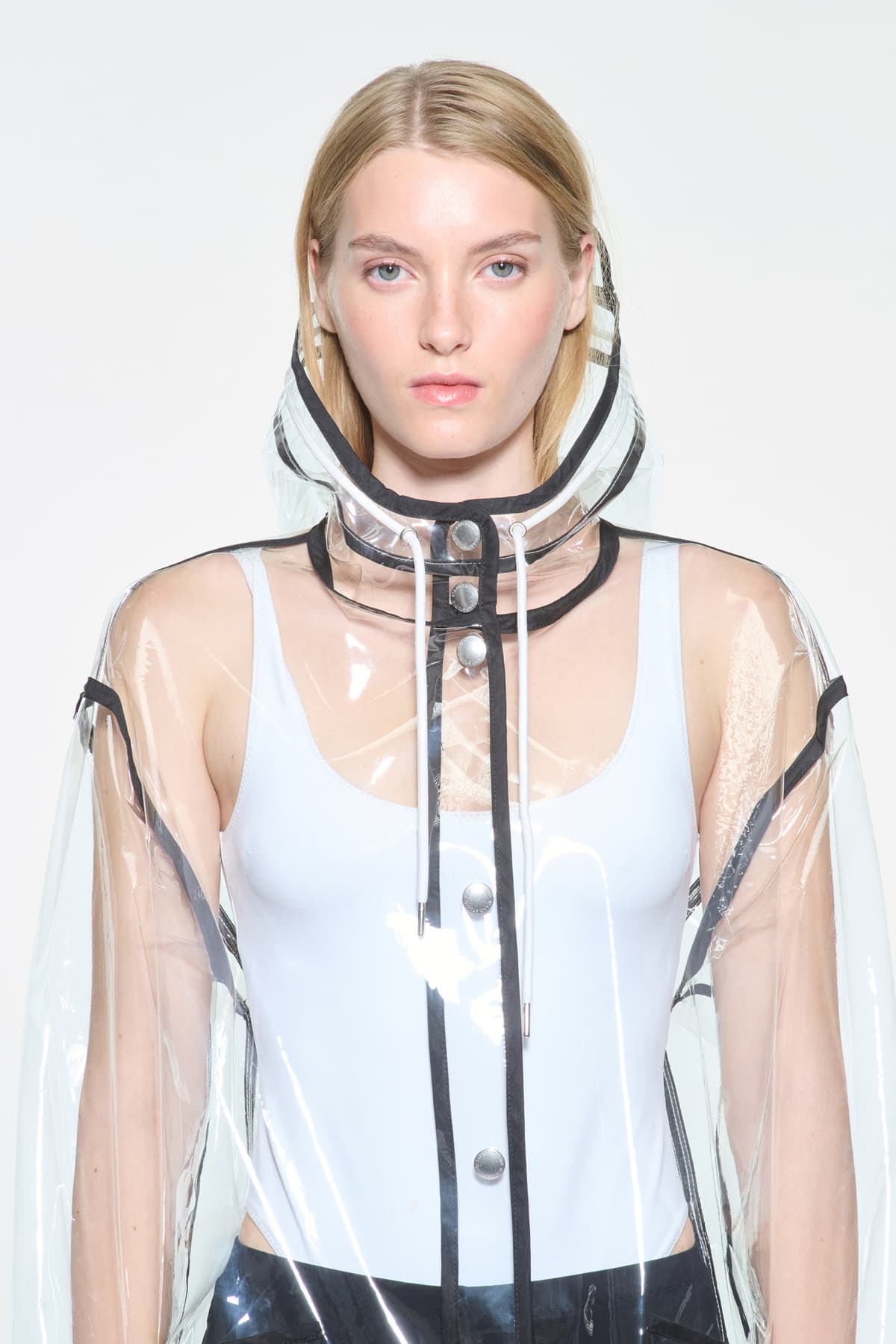Close-up view of the True Raincoat in Transparent, is a lightweight, fully transparent raincoat with contrast binding details.