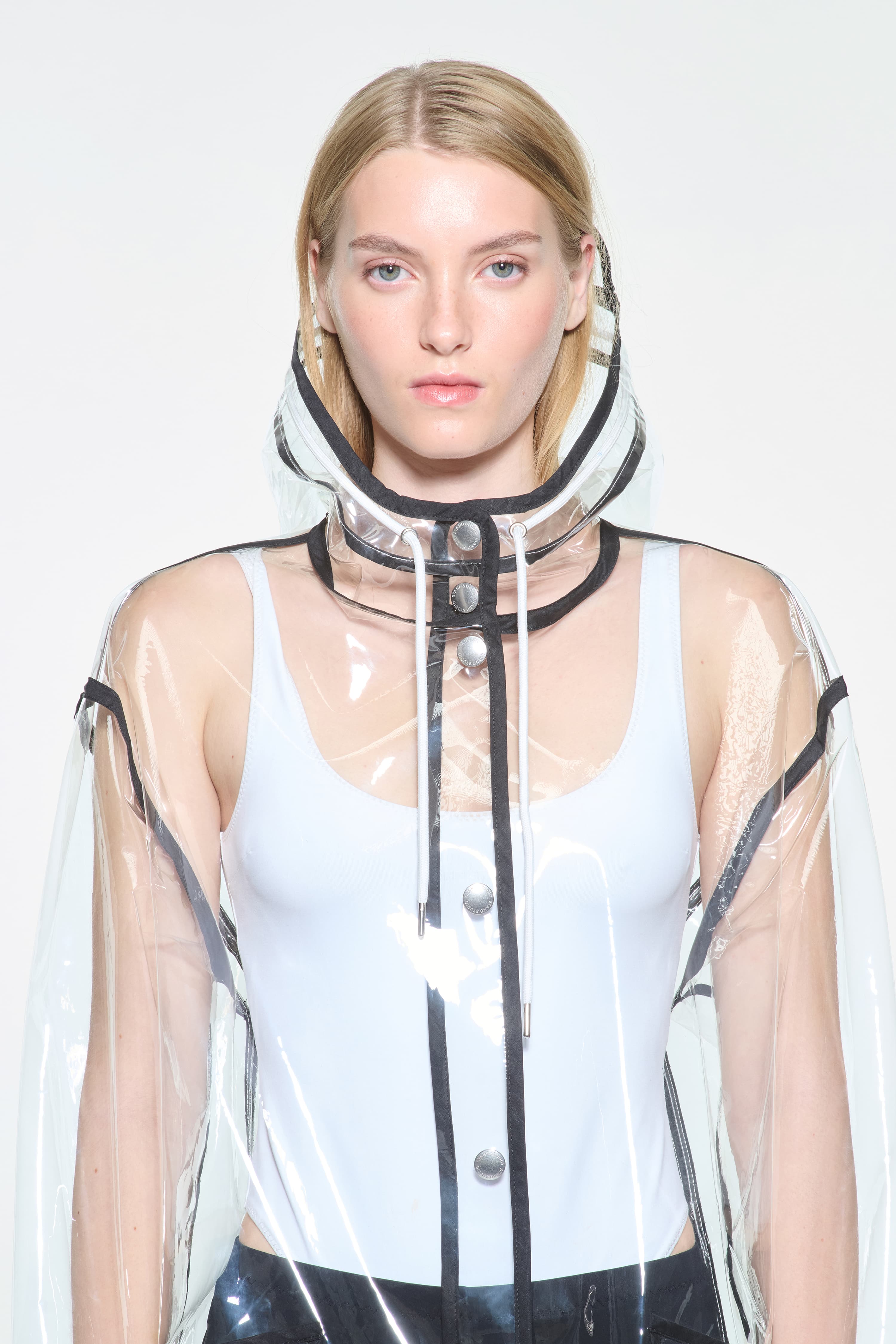 Close-up view of the True Raincoat in Transparent, is a lightweight, fully transparent raincoat with contrast binding details.