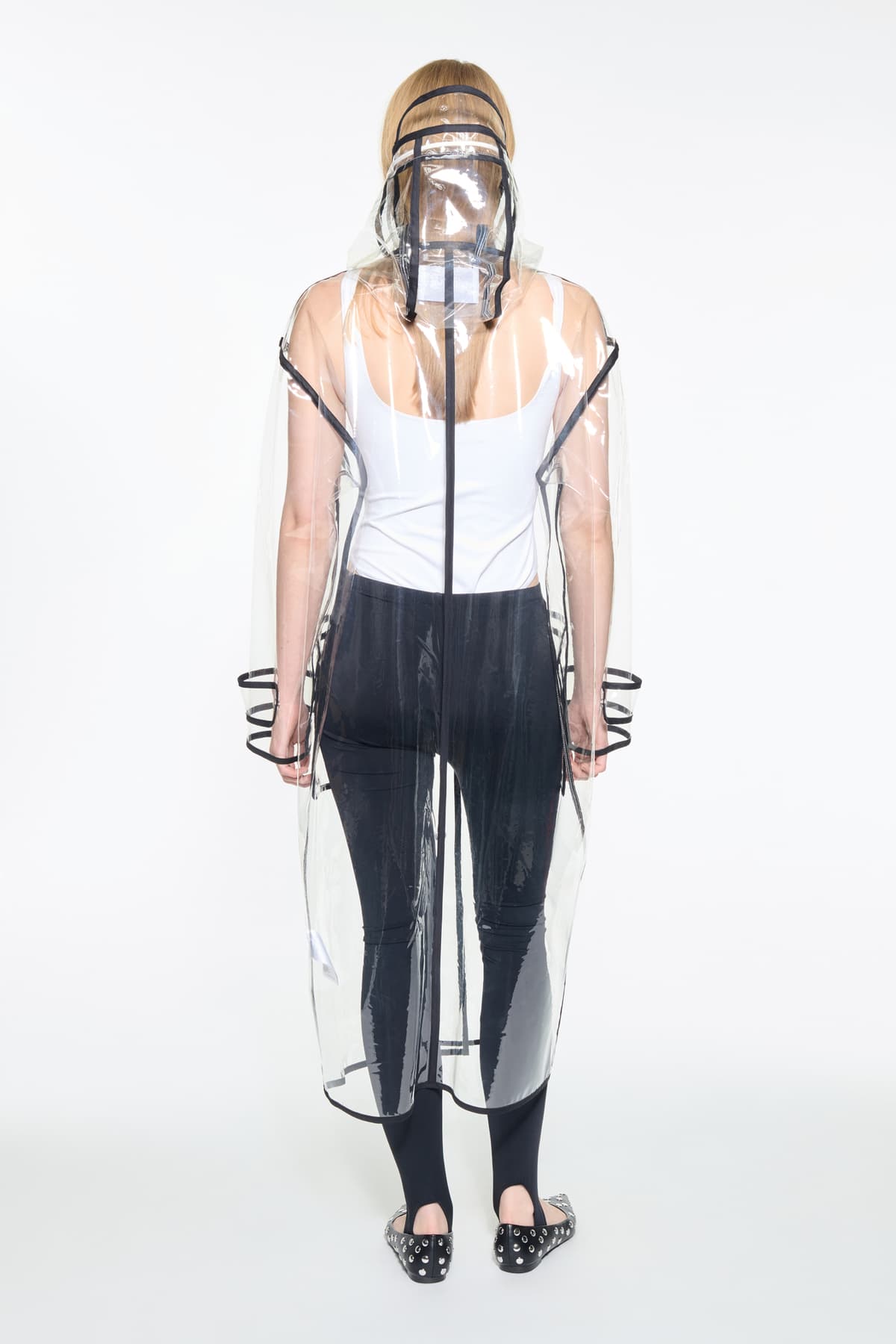 Back view of the True Raincoat in Transparent, is a lightweight, fully transparent raincoat with contrast binding details.