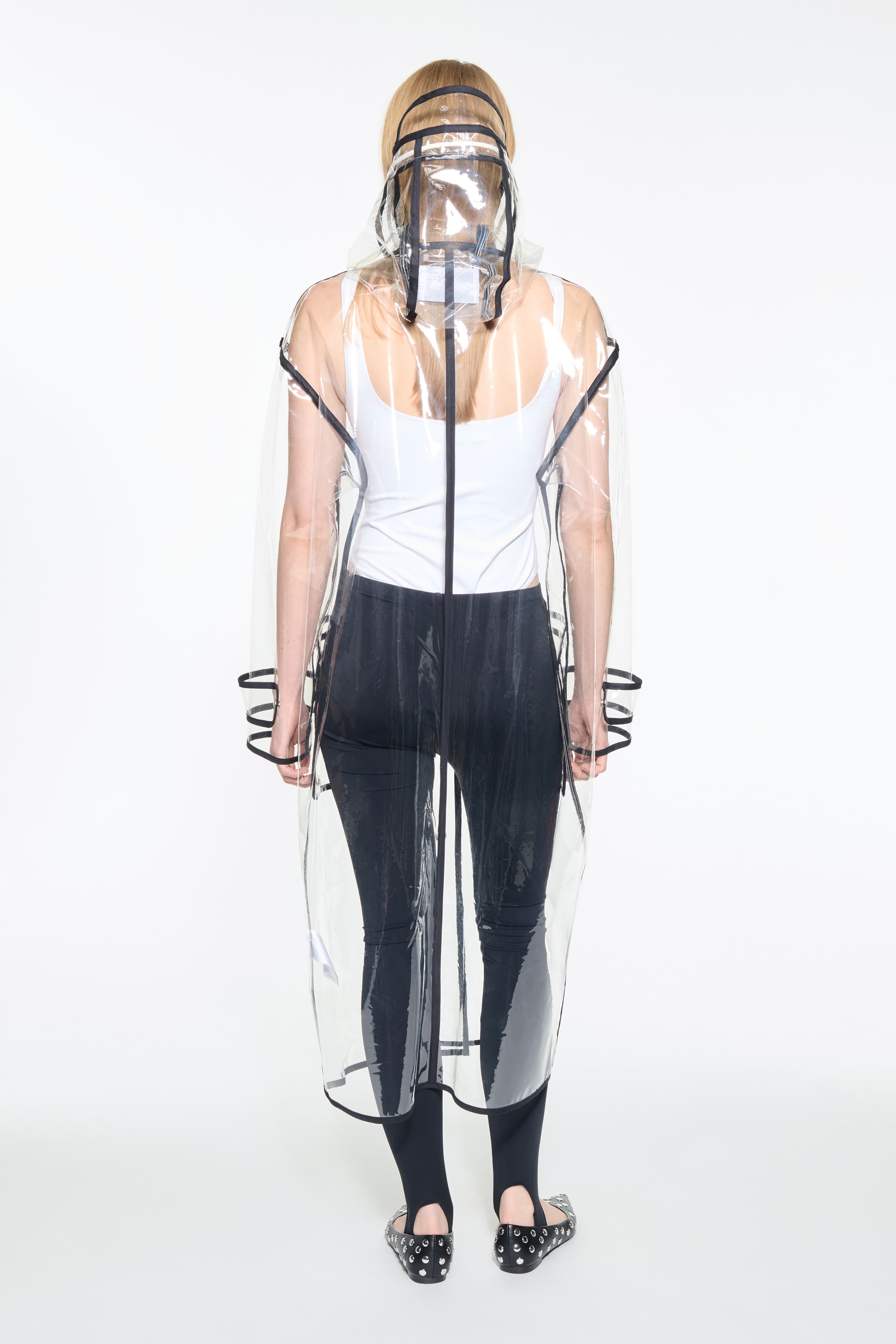 Back view of the True Raincoat in Transparent, is a lightweight, fully transparent raincoat with contrast binding details.