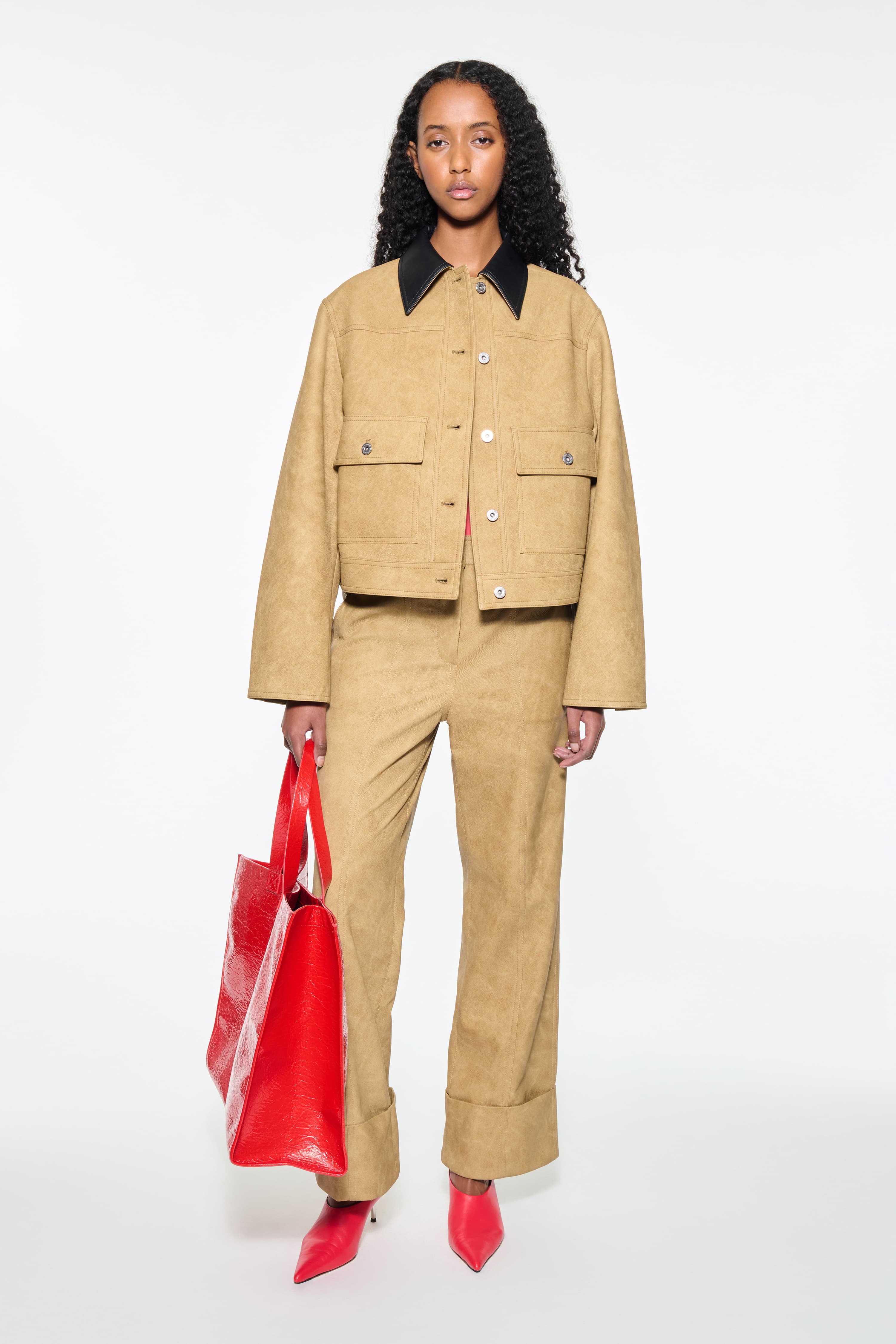 Front view of the Esther Jacket in Sand, is a cropped faux leather jacket with a casual silhouette.