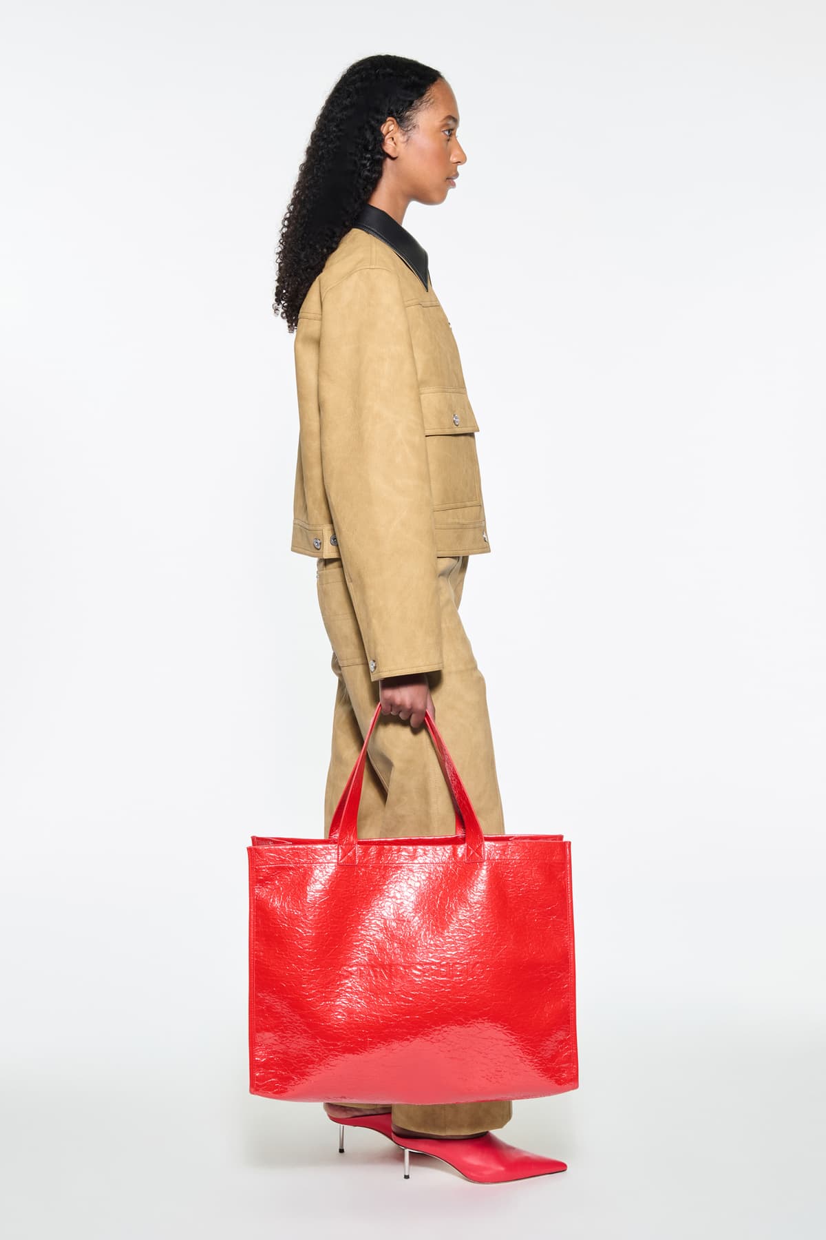 Side view of the Esther Jacket in Sand, is a cropped faux leather jacket with a casual silhouette.