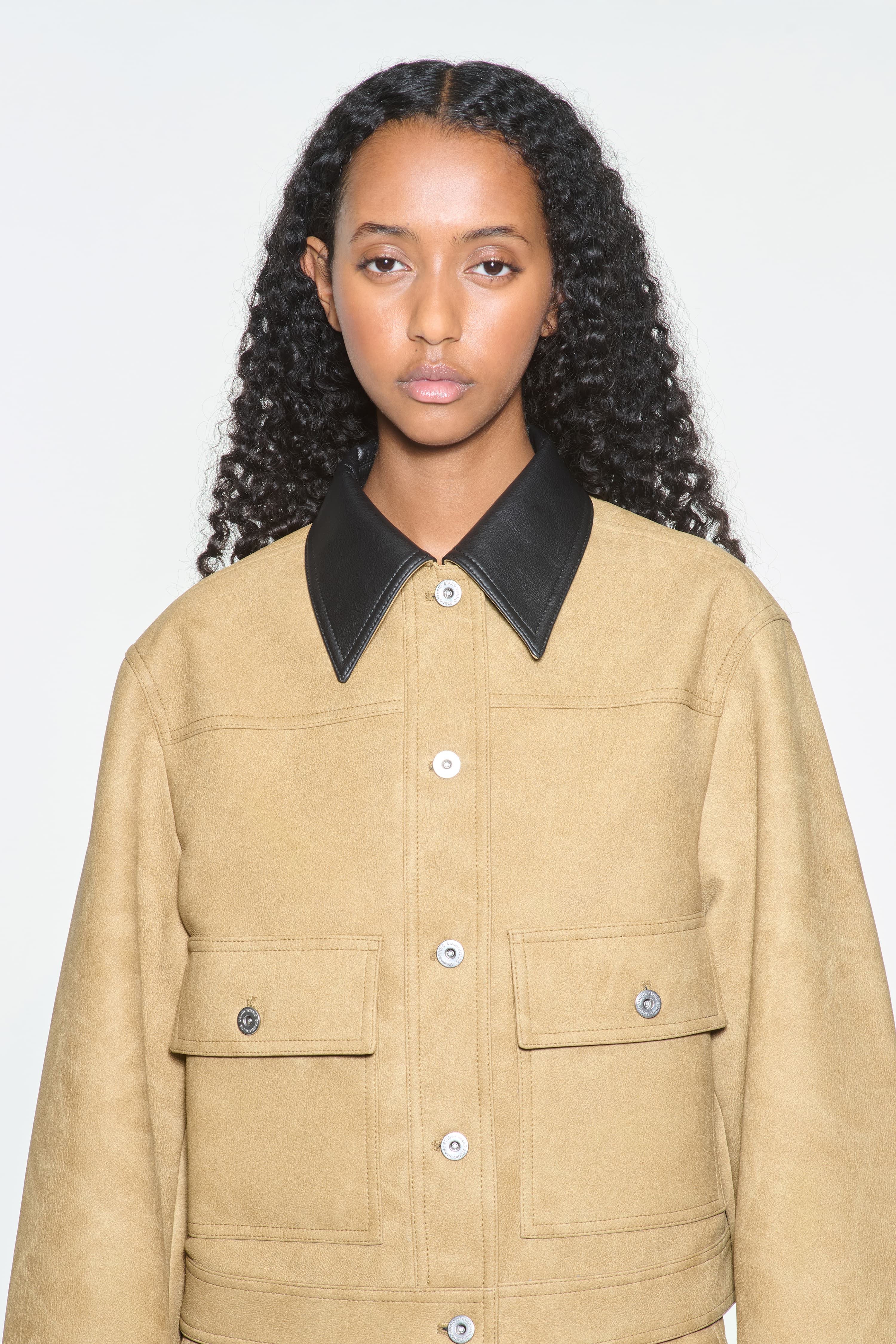 Close-up view of the Esther Jacket in Sand, is a cropped faux leather jacket with a casual silhouette.