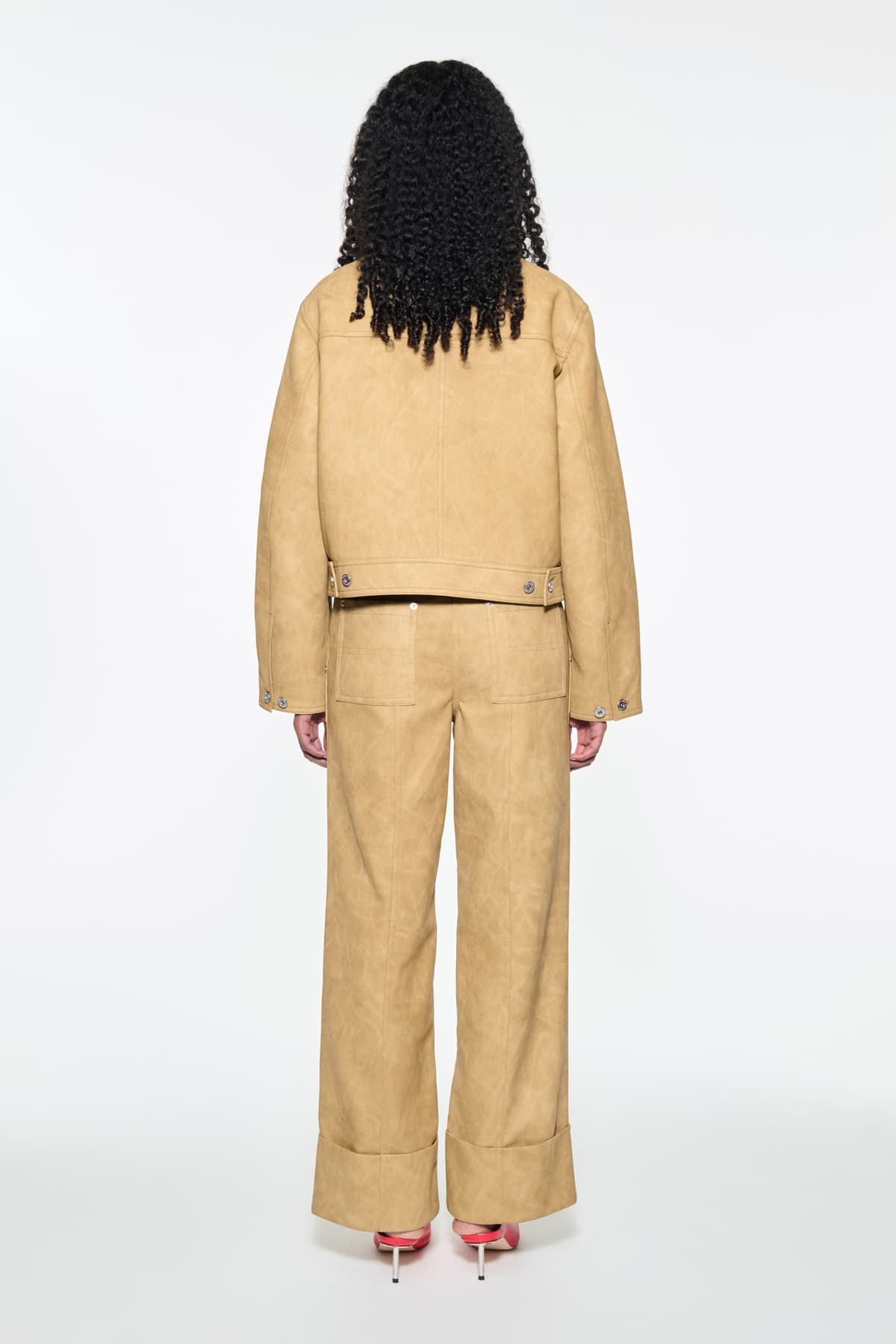Back view of the Esther Jacket in Sand, is a cropped faux leather jacket with a casual silhouette.
